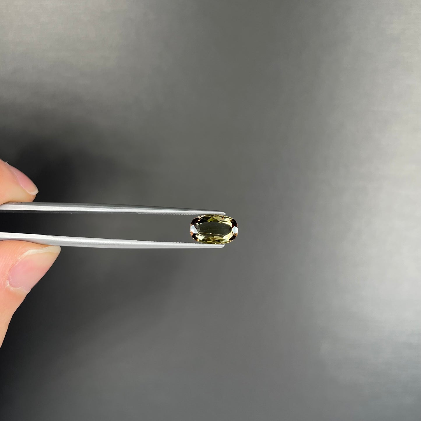 A modified oval cut andalusite gemstone. The stone has eye-visible rutile inclusions.