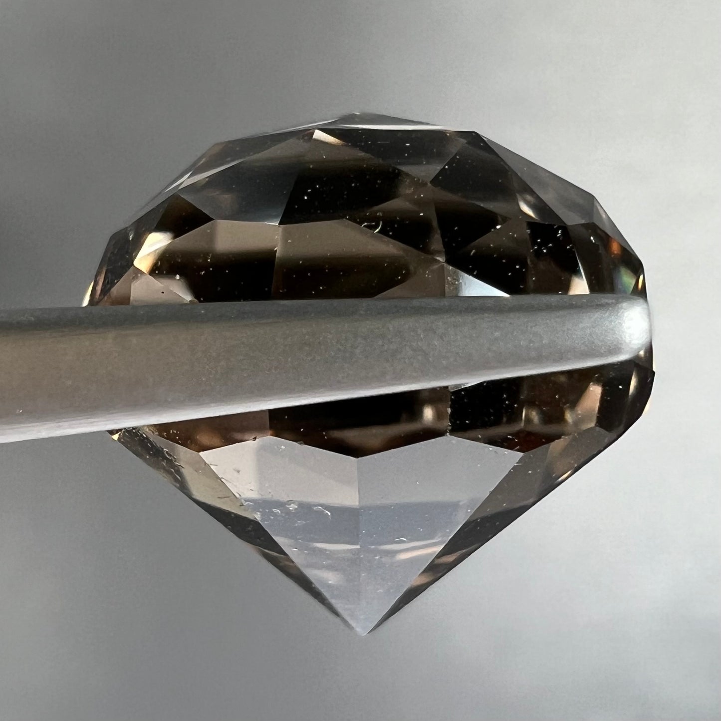 A loose, modified brilliant Portuguese cut smoky quartz gemstone.