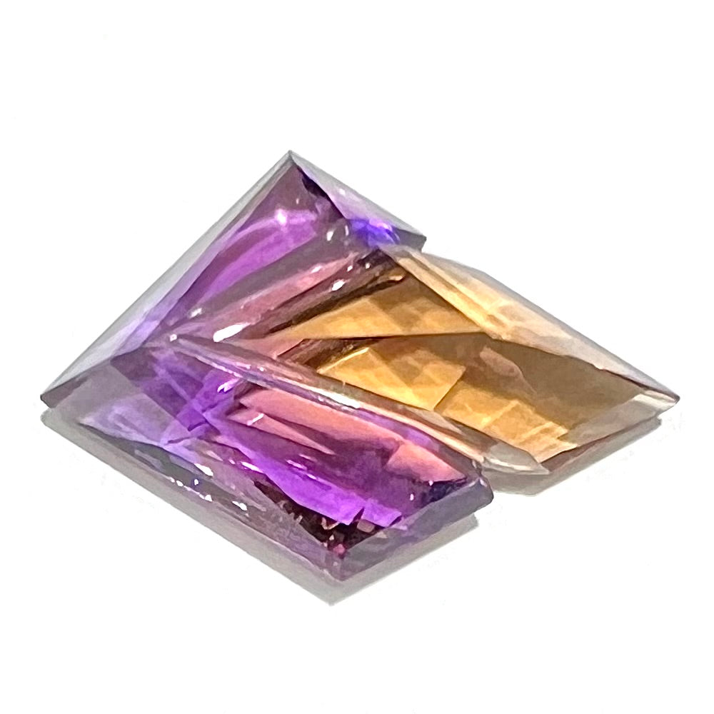 A loose, faceted fantasy cut ametrine gemstone cut by famous carver, Arthur Lee Anderson.