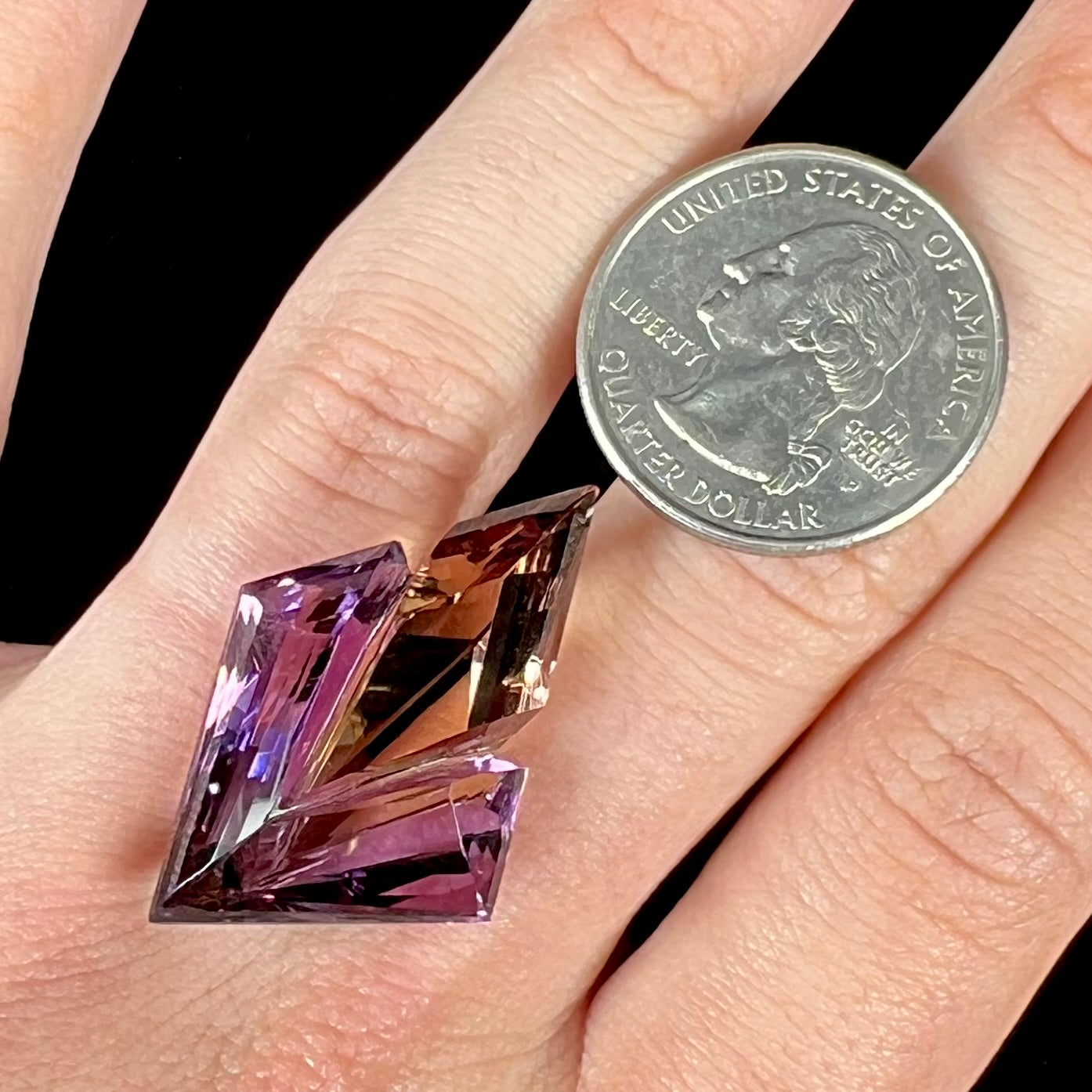 A loose, faceted fantasy cut ametrine gemstone cut by famous carver, Arthur Lee Anderson.