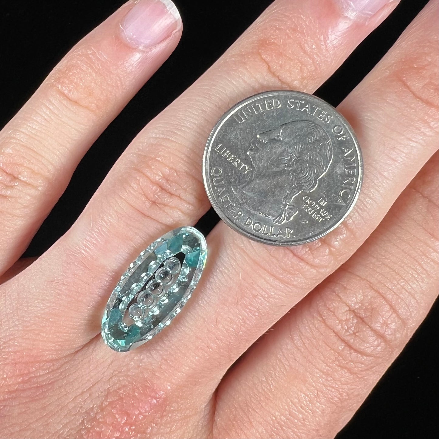 An oval fantasy cut greenish blue aquamarine stone cut by gem carver, Arthur Lee Anderson.