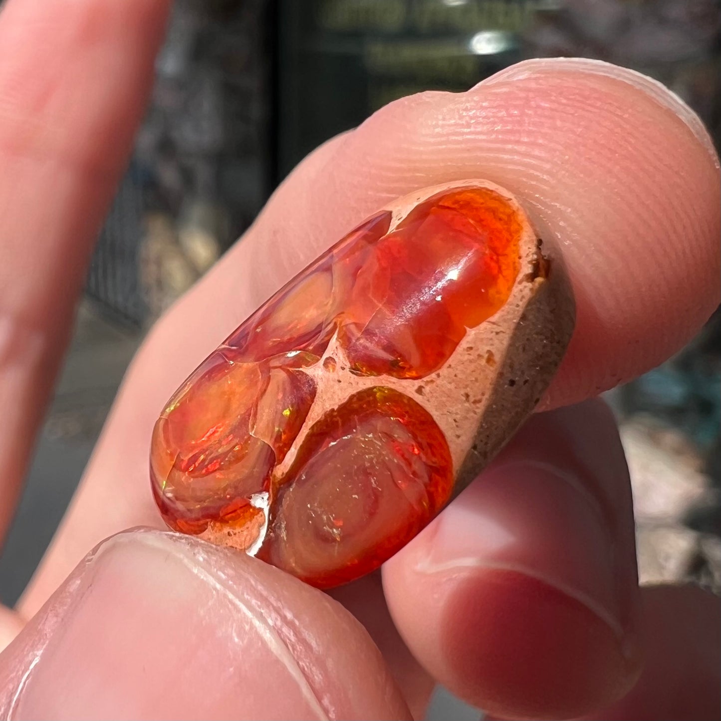 A loose Mexican matrix fire opal stone. The opal is orange with green flashes.
