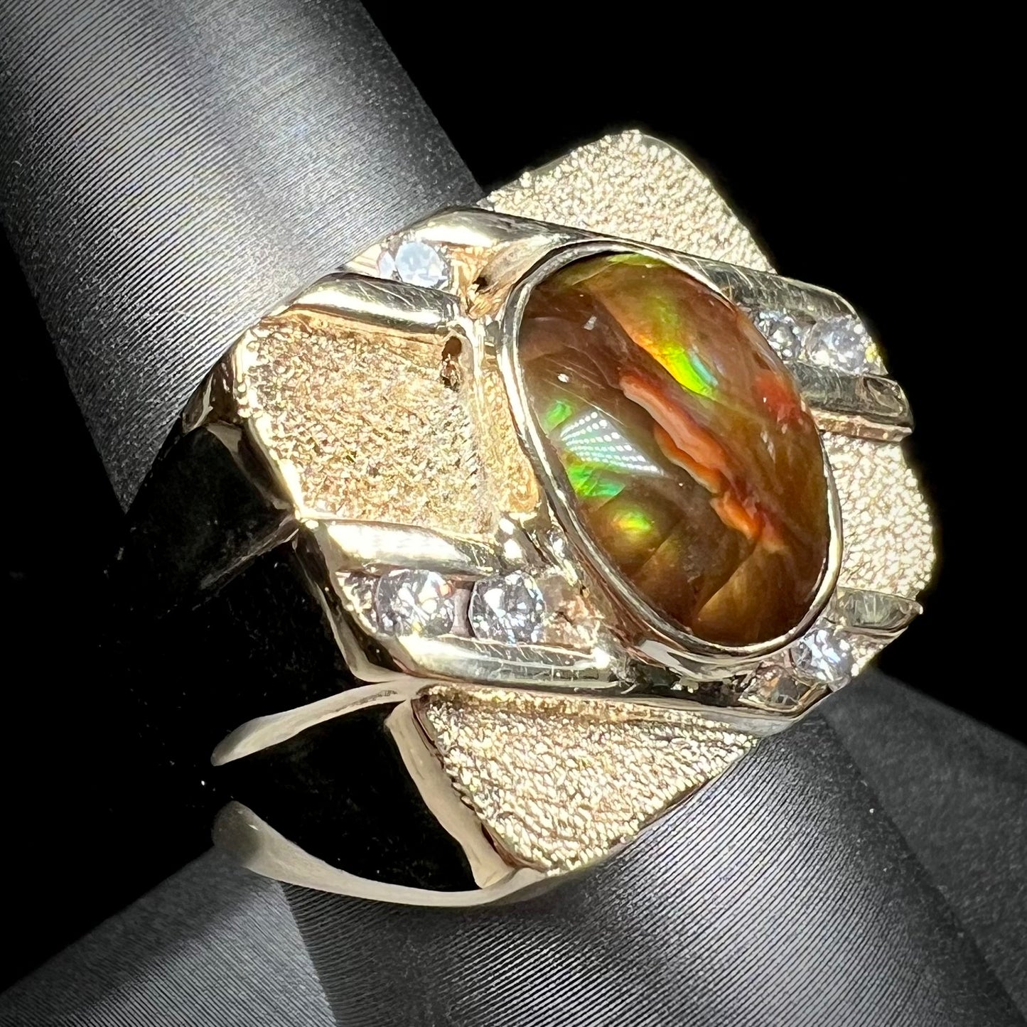 A yellow gold men's ring channel set with diamonds and bezel set with a Mexican fire agate stone.