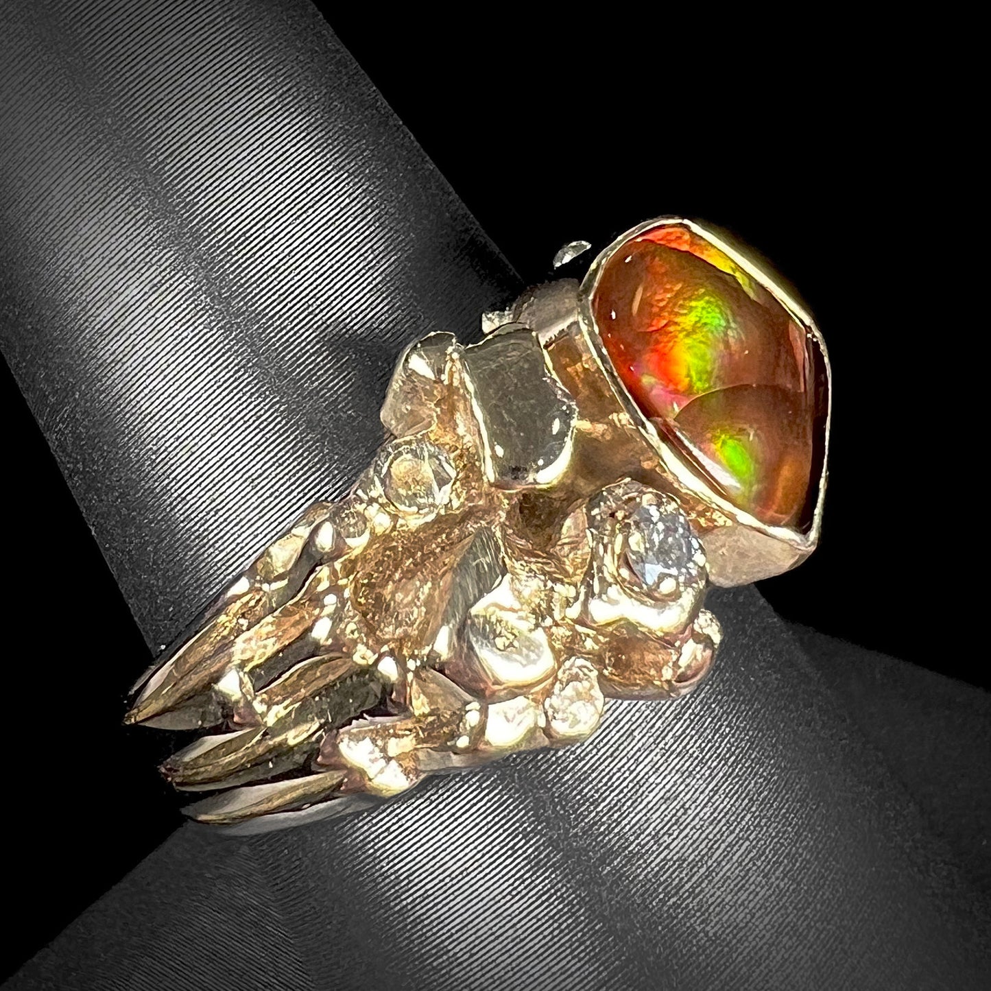 A men's yellow gold, nugget style ring set with a Mexican fire agate stone and a diamond accent.