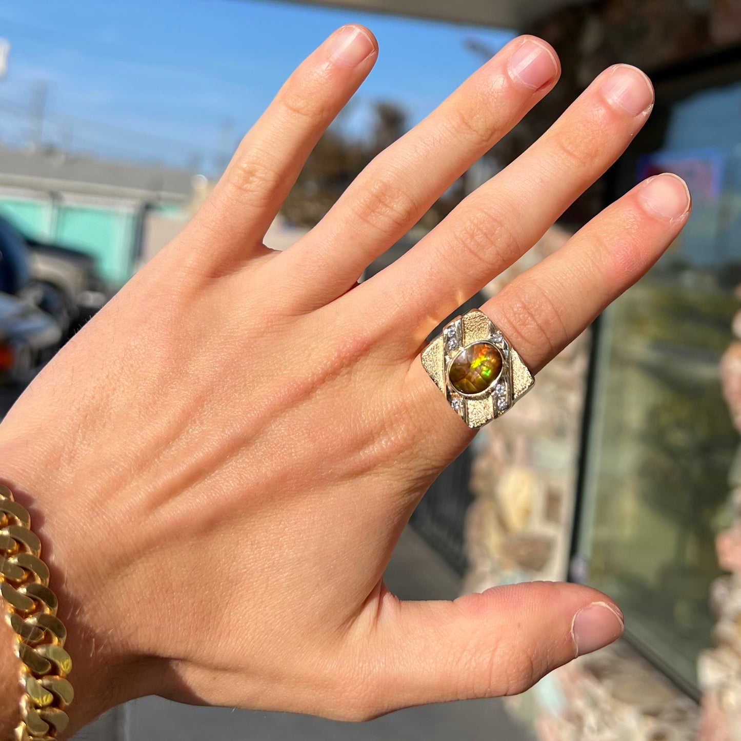 A yellow gold men's ring channel set with diamonds and bezel set with a Mexican fire agate stone.