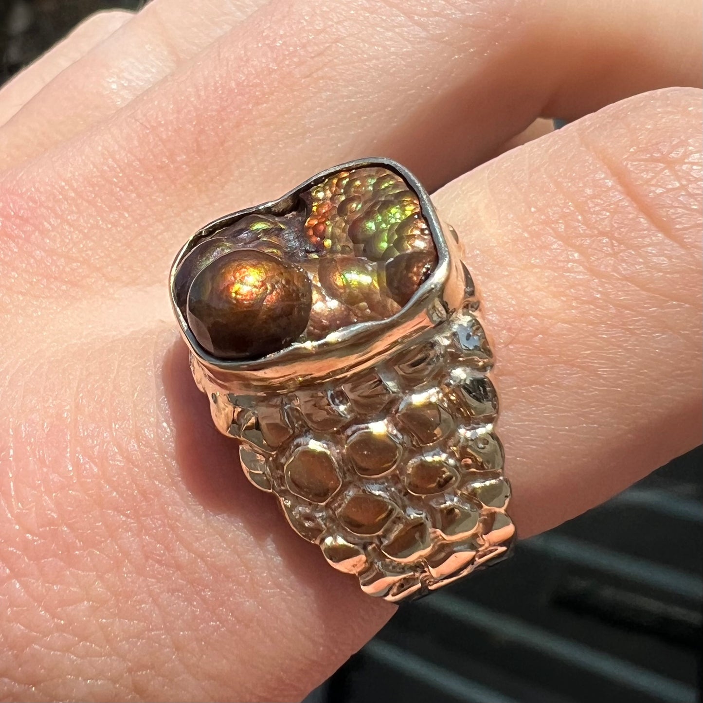 A men's yellow gold, nugget style ring set with a bubbly, California fire agate stone.