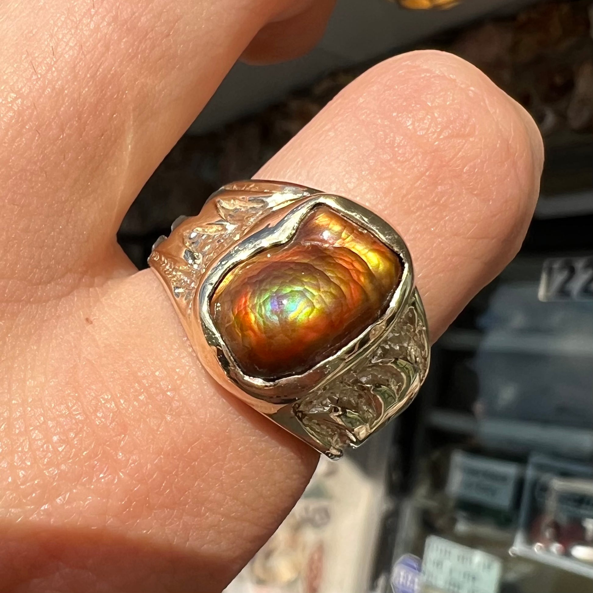 A man's yellow gold solitaire ring set with a freeform shaped Mexican fire agate stone.  The stone has a purple bull's eye pattern.