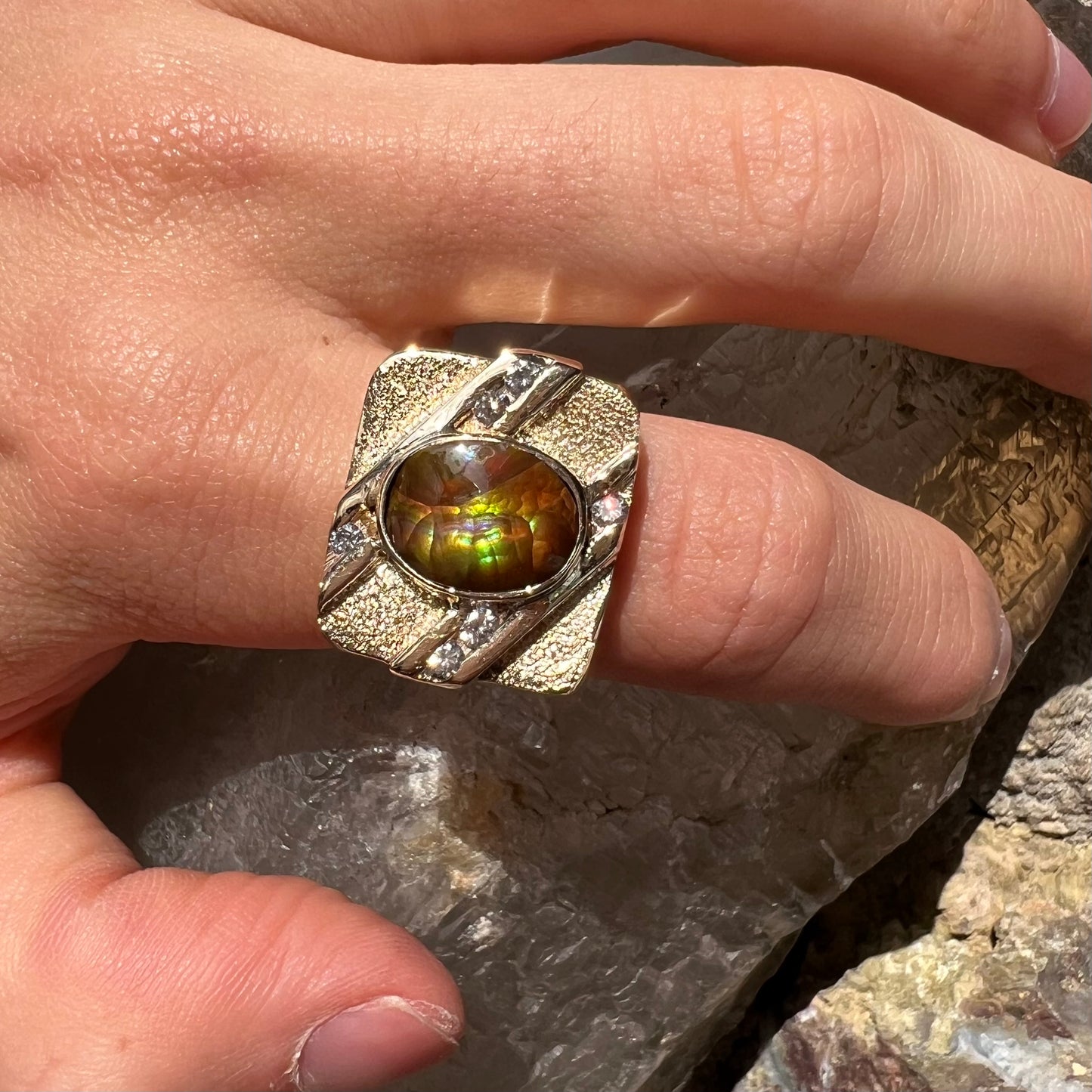 A yellow gold men's ring channel set with diamonds and bezel set with a Mexican fire agate stone.