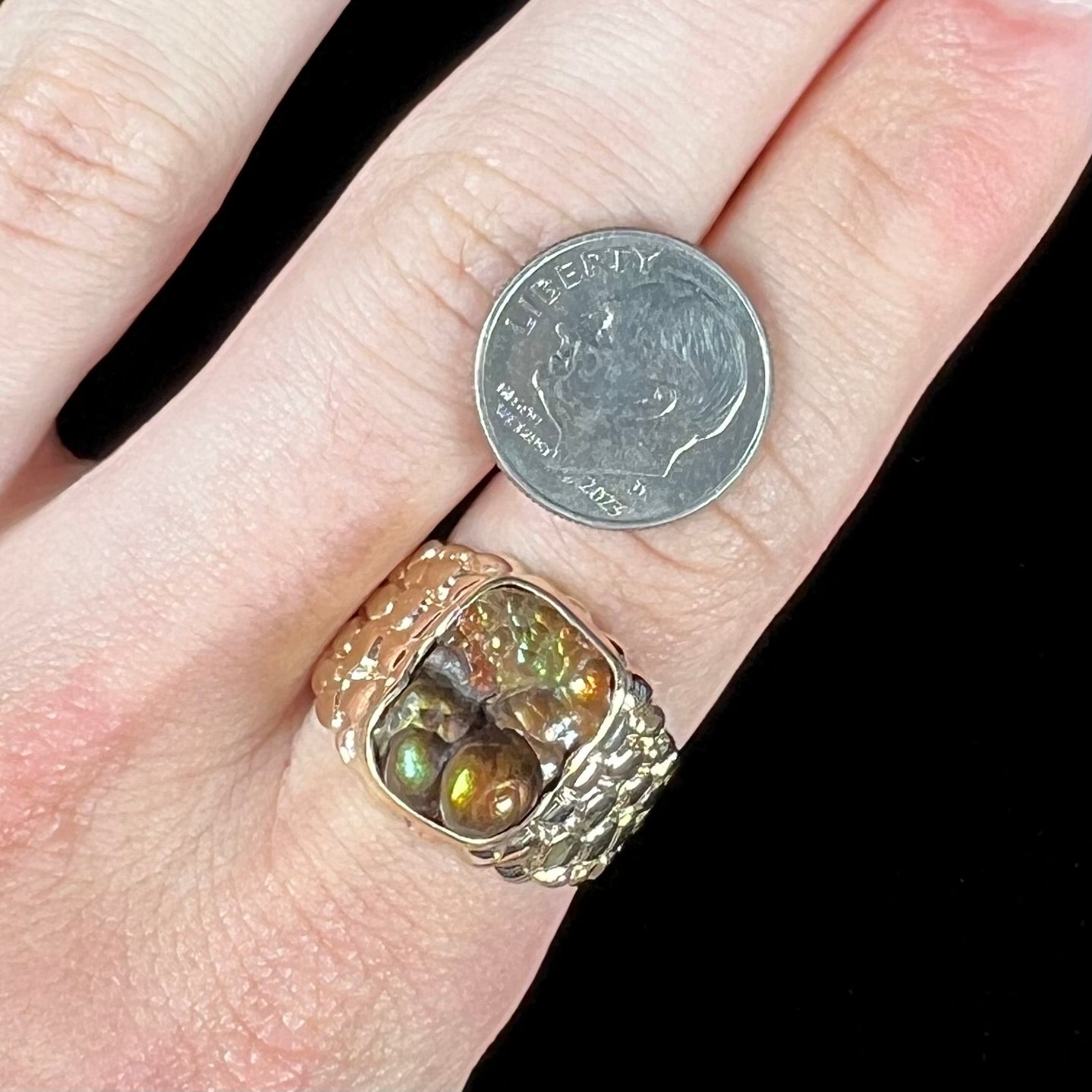 A men's yellow gold, nugget style ring set with a bubbly, California fire agate stone.