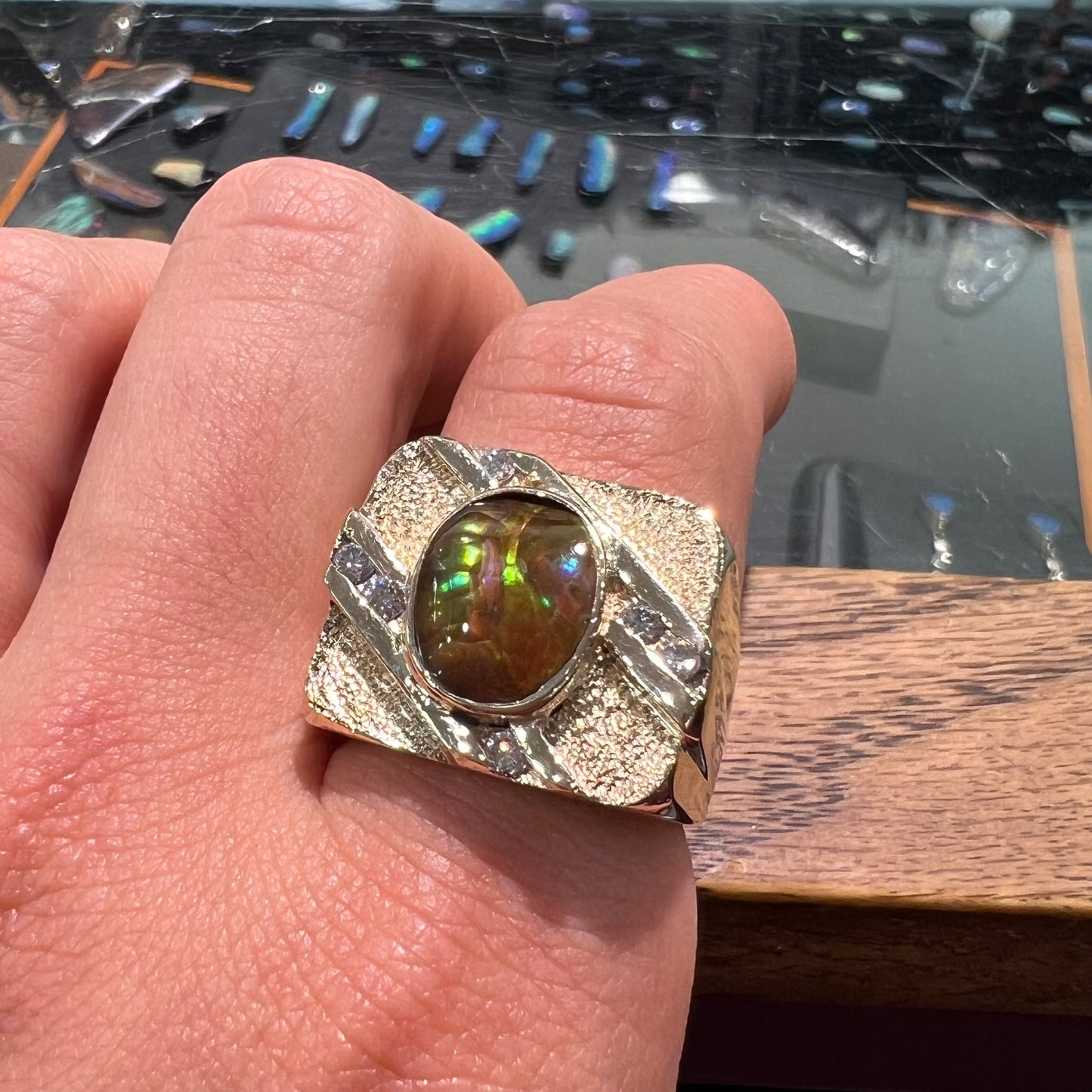 A yellow gold men's ring channel set with diamonds and bezel set with a Mexican fire agate stone.