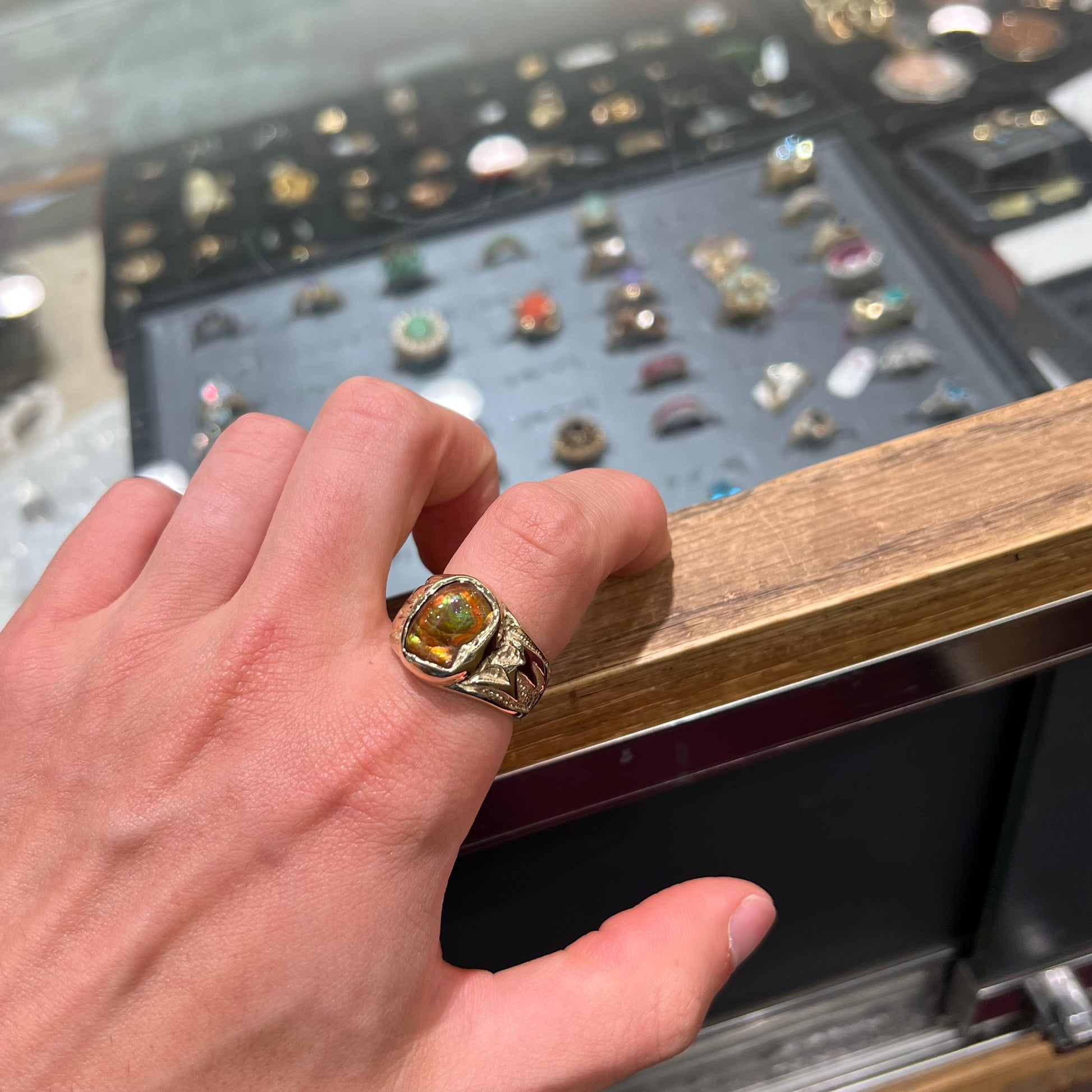 A man's yellow gold solitaire ring set with a freeform shaped Mexican fire agate stone.  The stone has a purple bull's eye pattern.