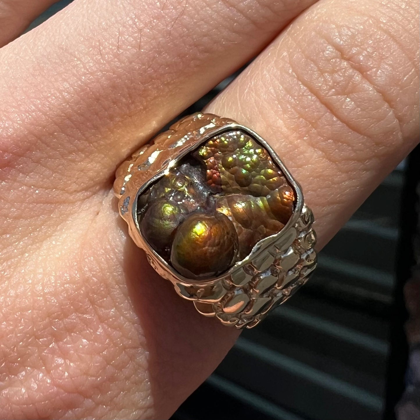 A men's yellow gold, nugget style ring set with a bubbly, California fire agate stone.