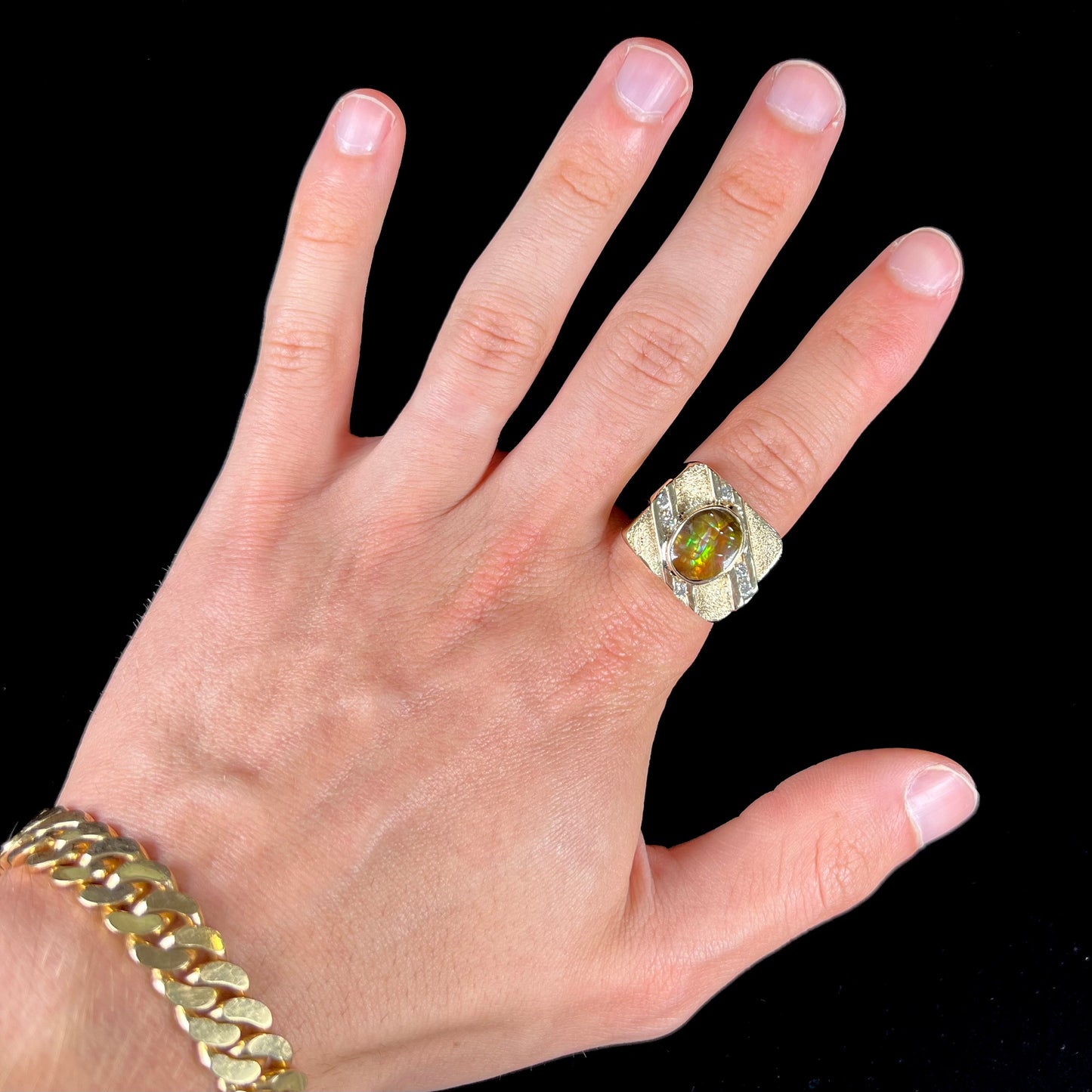 A yellow gold men's ring channel set with diamonds and bezel set with a Mexican fire agate stone.