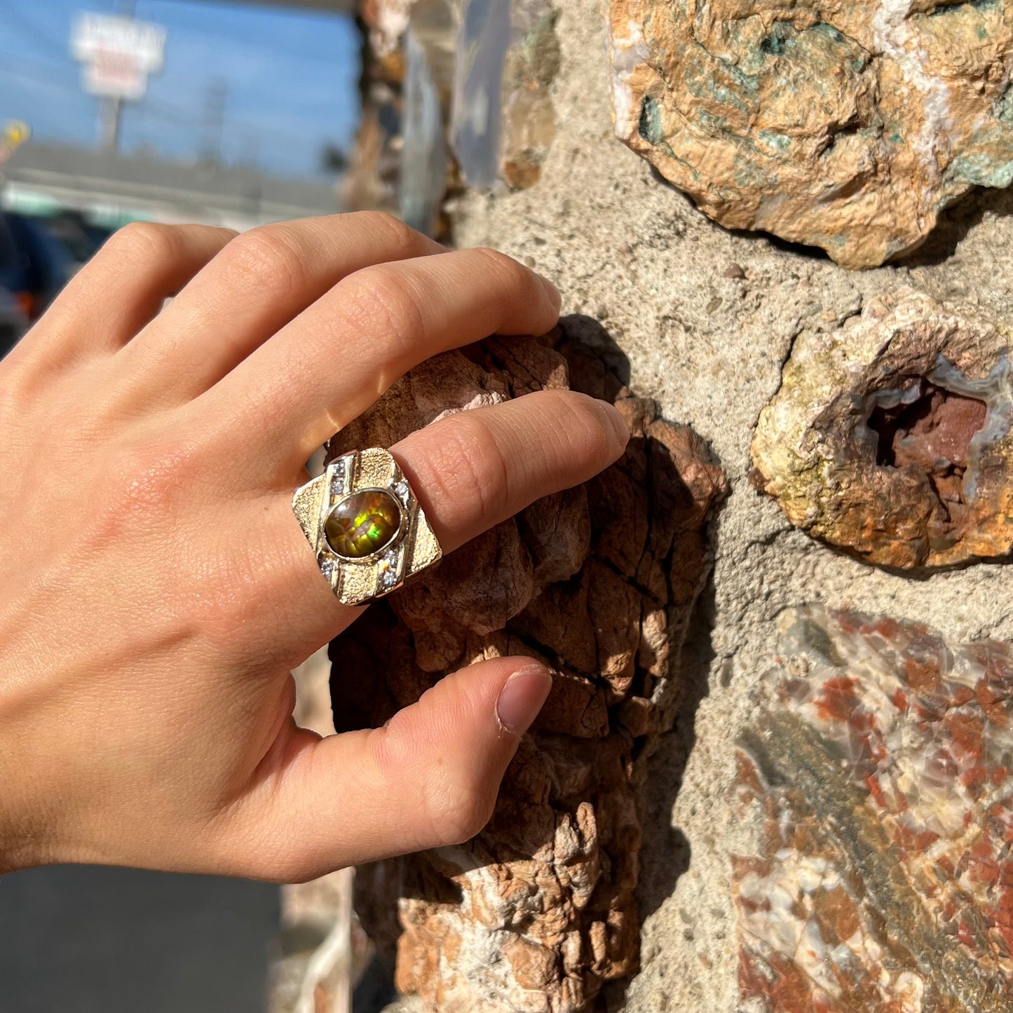 A yellow gold men's ring channel set with diamonds and bezel set with a Mexican fire agate stone.