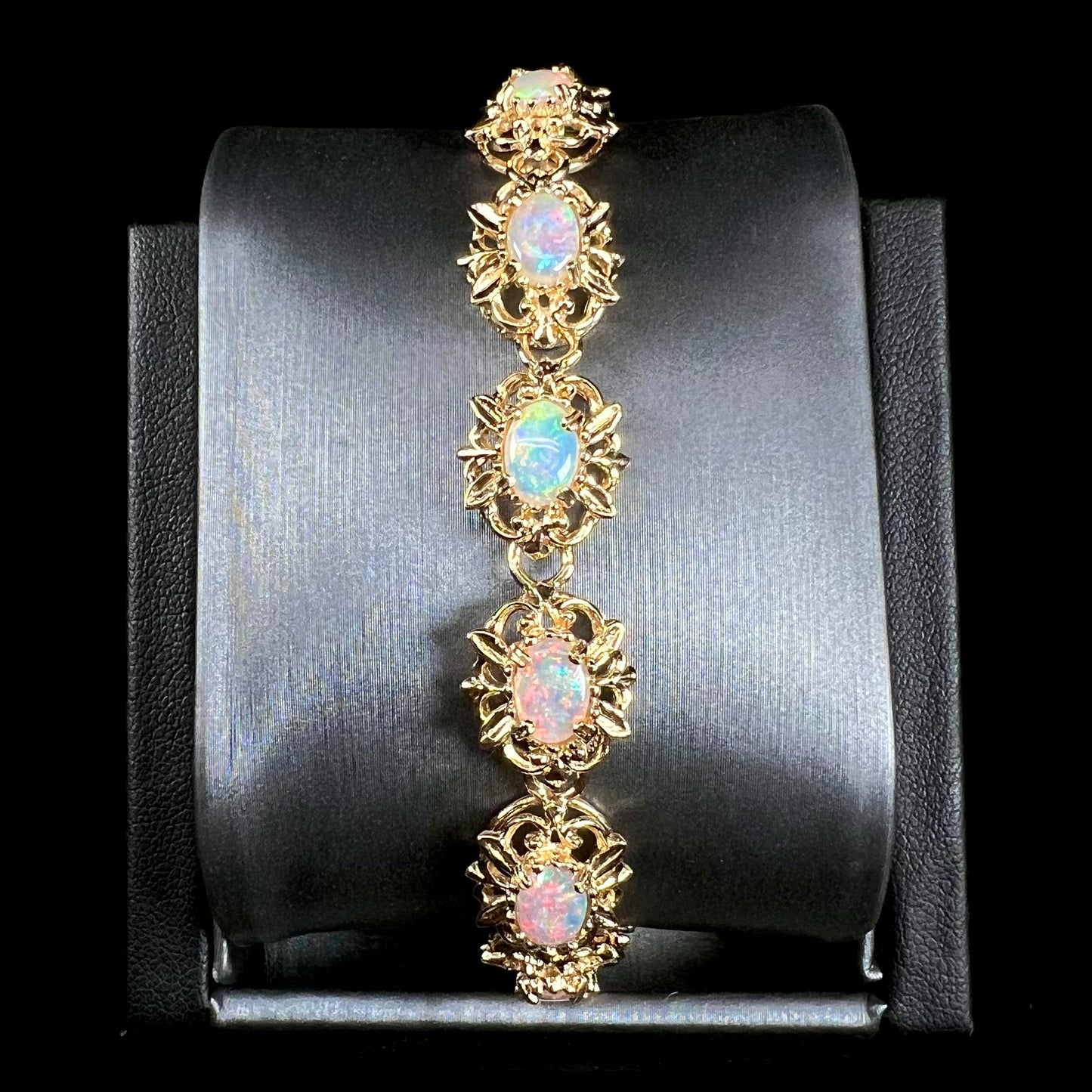 A ladies' yellow gold bracelet set with natural, oval cabochon cut white crystal opals.