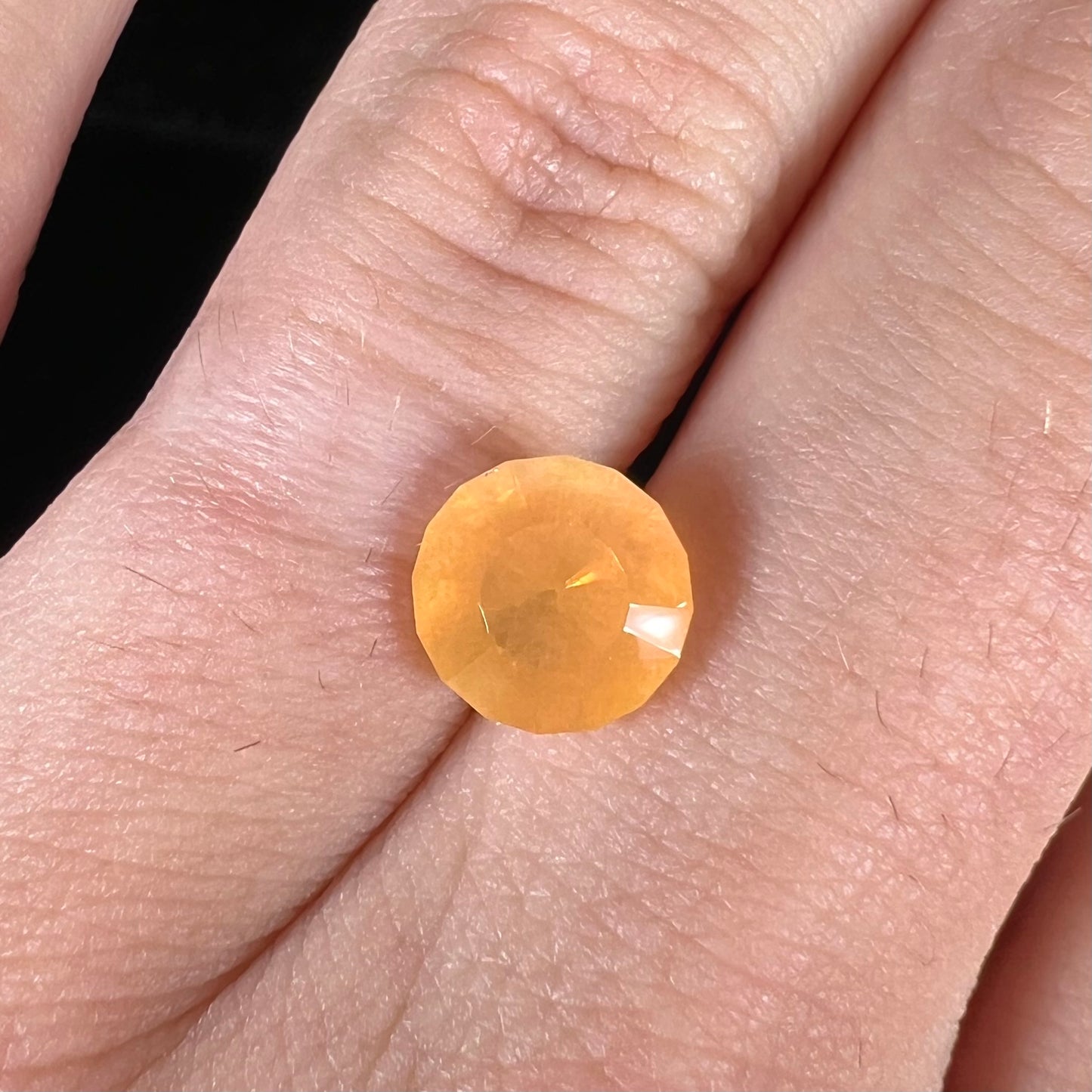 A loose, faceted round cut fire opal from Mexico. The stone is yellow orange in body color.