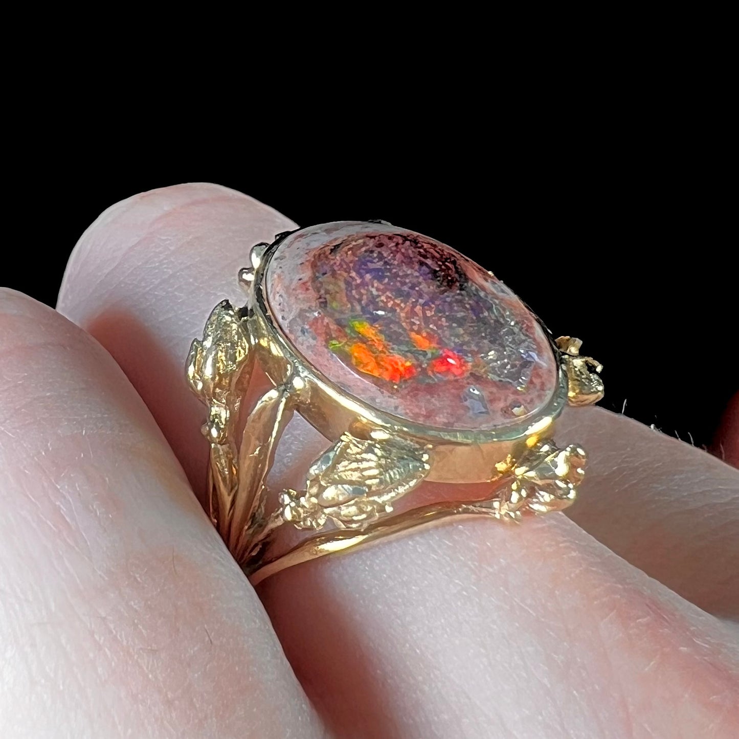 A ladies' estate yellow gold solitaire ring set with an oval cabochon cut natural Cantera fire opal.