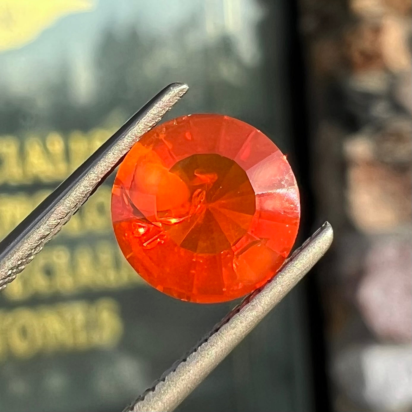 A faceted round cut natural fire opal from Mexico. The stone is a bright orange color.