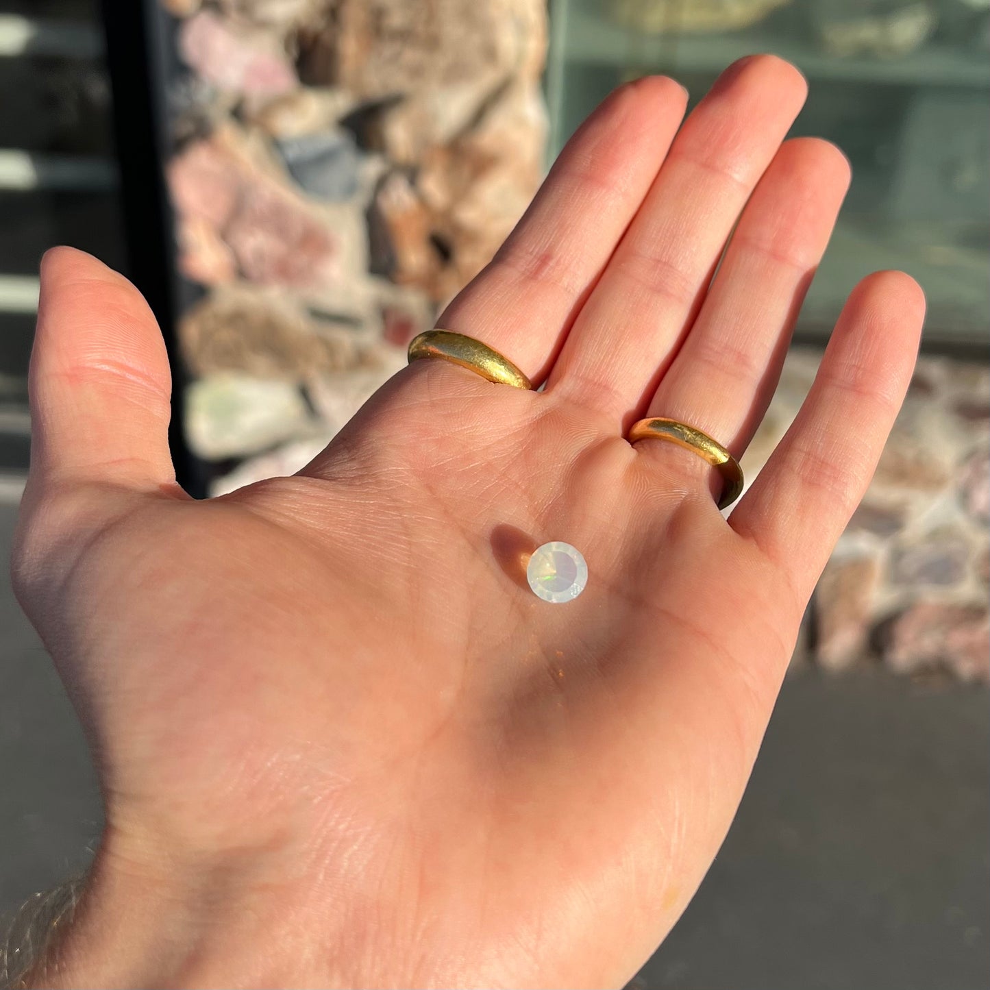 A loose, yellowish-white bodied Mexican fire opal. The stone is a faceted round cut.