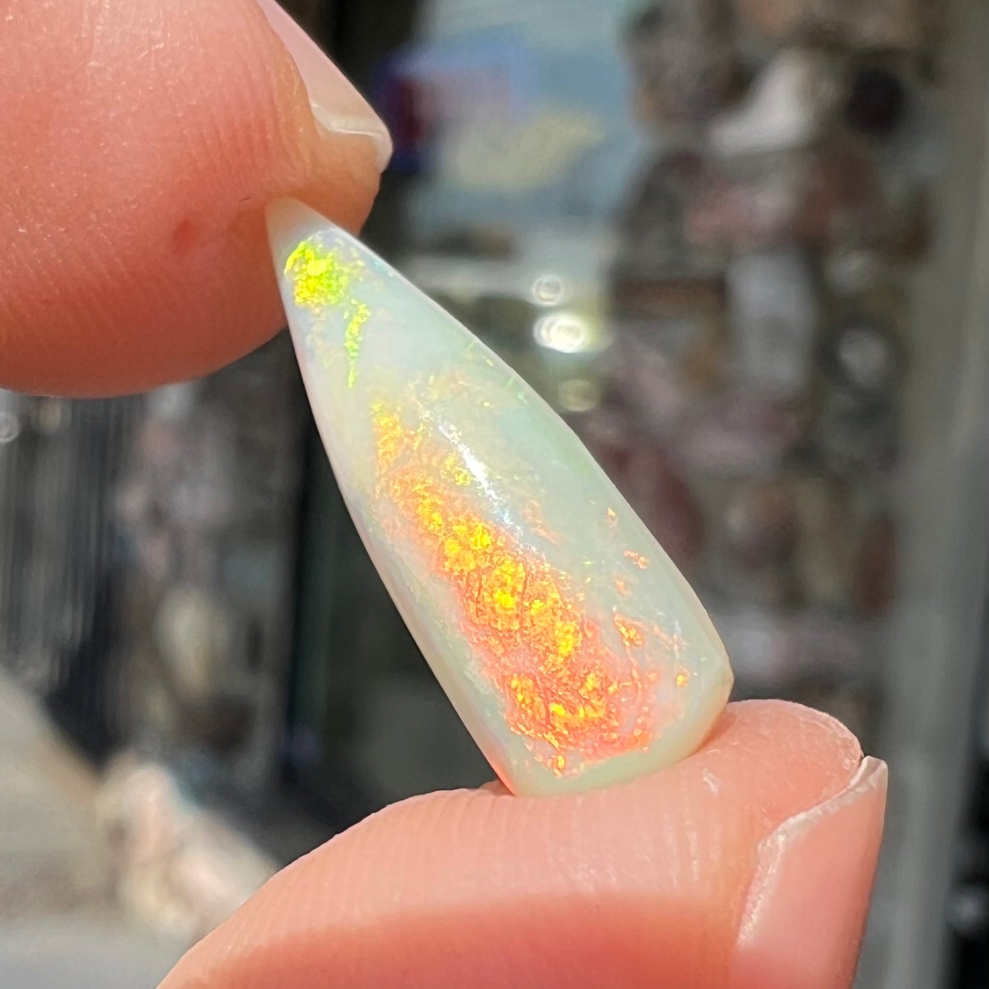 An opalized belemnite fossil from Coober Pedy, Australia. The specimen has red, yellow, and green play of color.