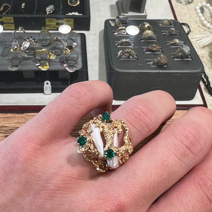 A vintage 1950's gold cluster ring set with freshwater pearls and green imitation emeralds.