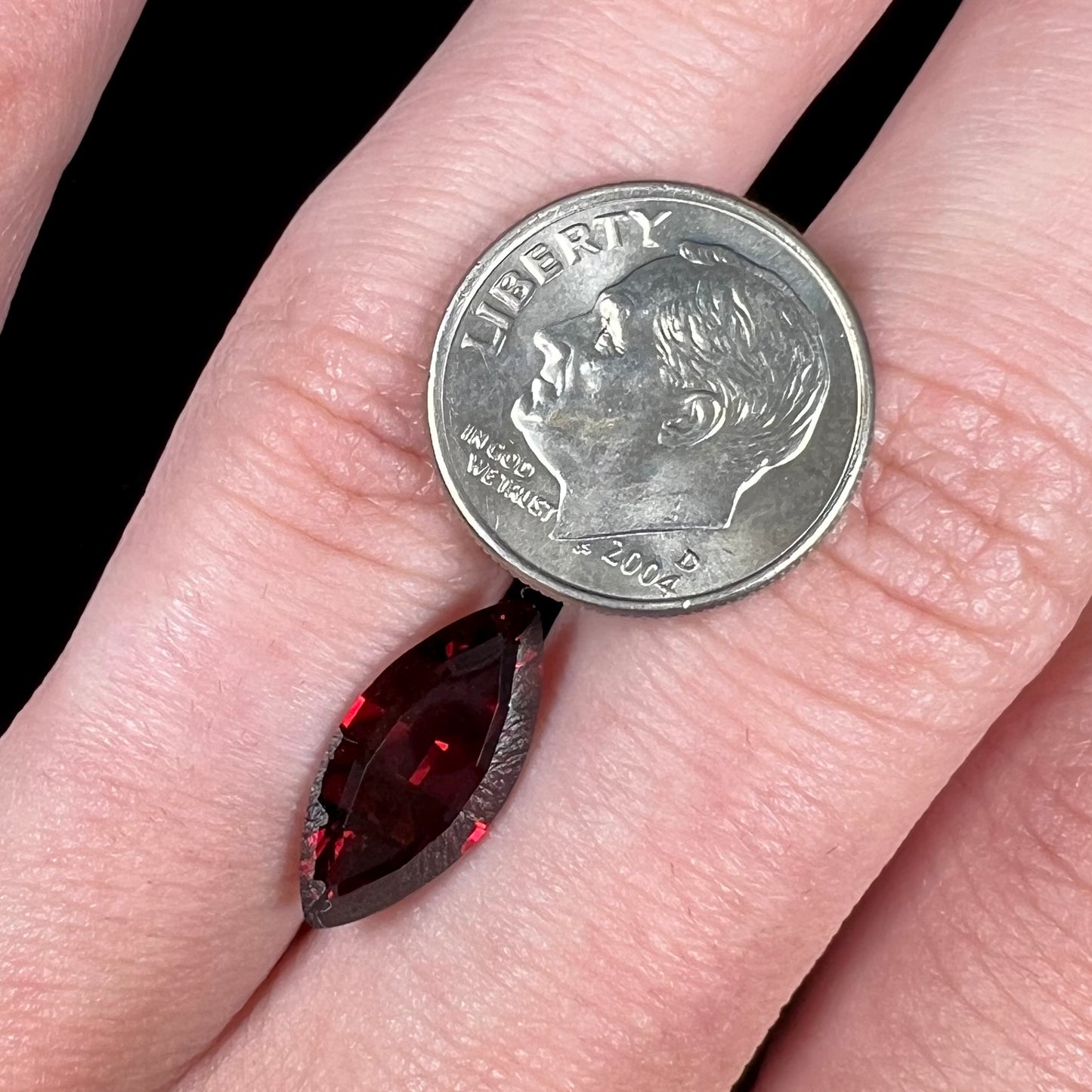 A faceted marquise cut red pyrope garnet stone.