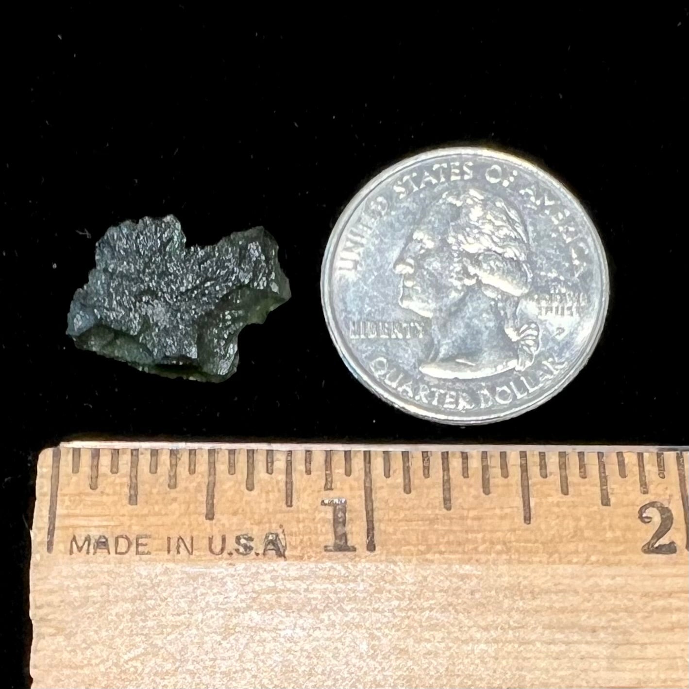 A natural, rough moldavite crystal. The stone is green color and transluscent.