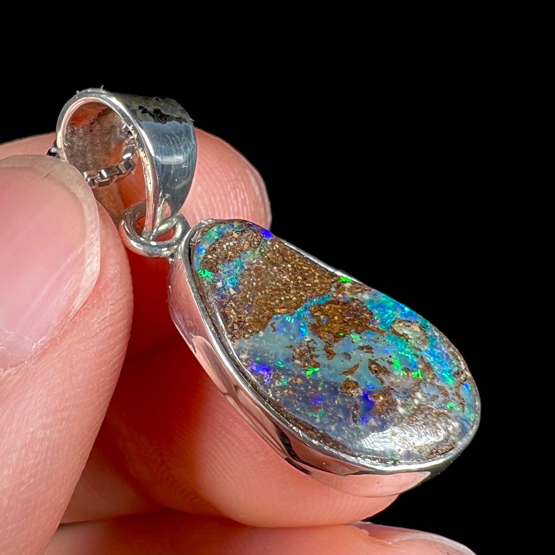 A sterling silver pendant set with an Australian boulder opal on a silver box chain.