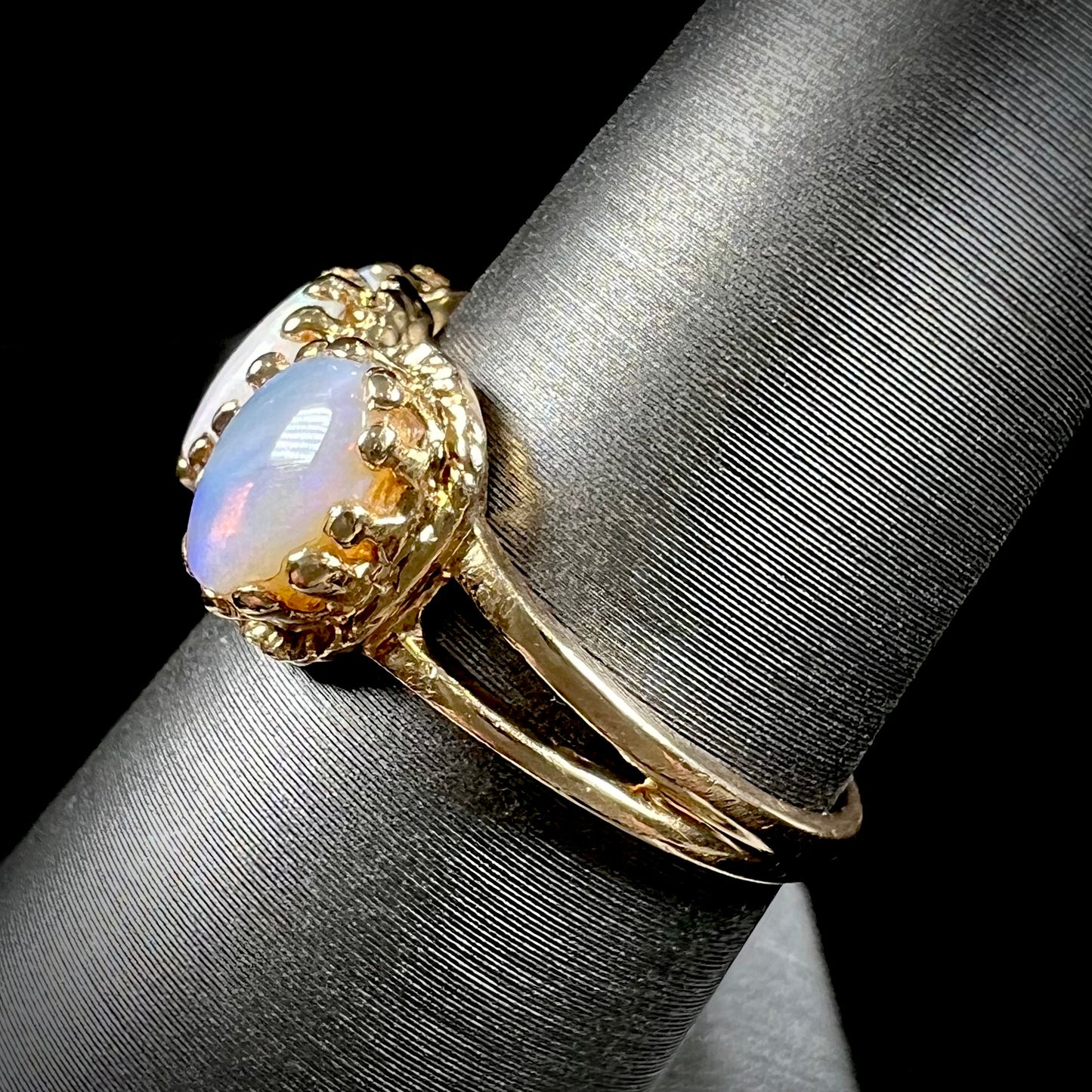 A vintage ladies' three stone gold ring set with natural white crystal opals.