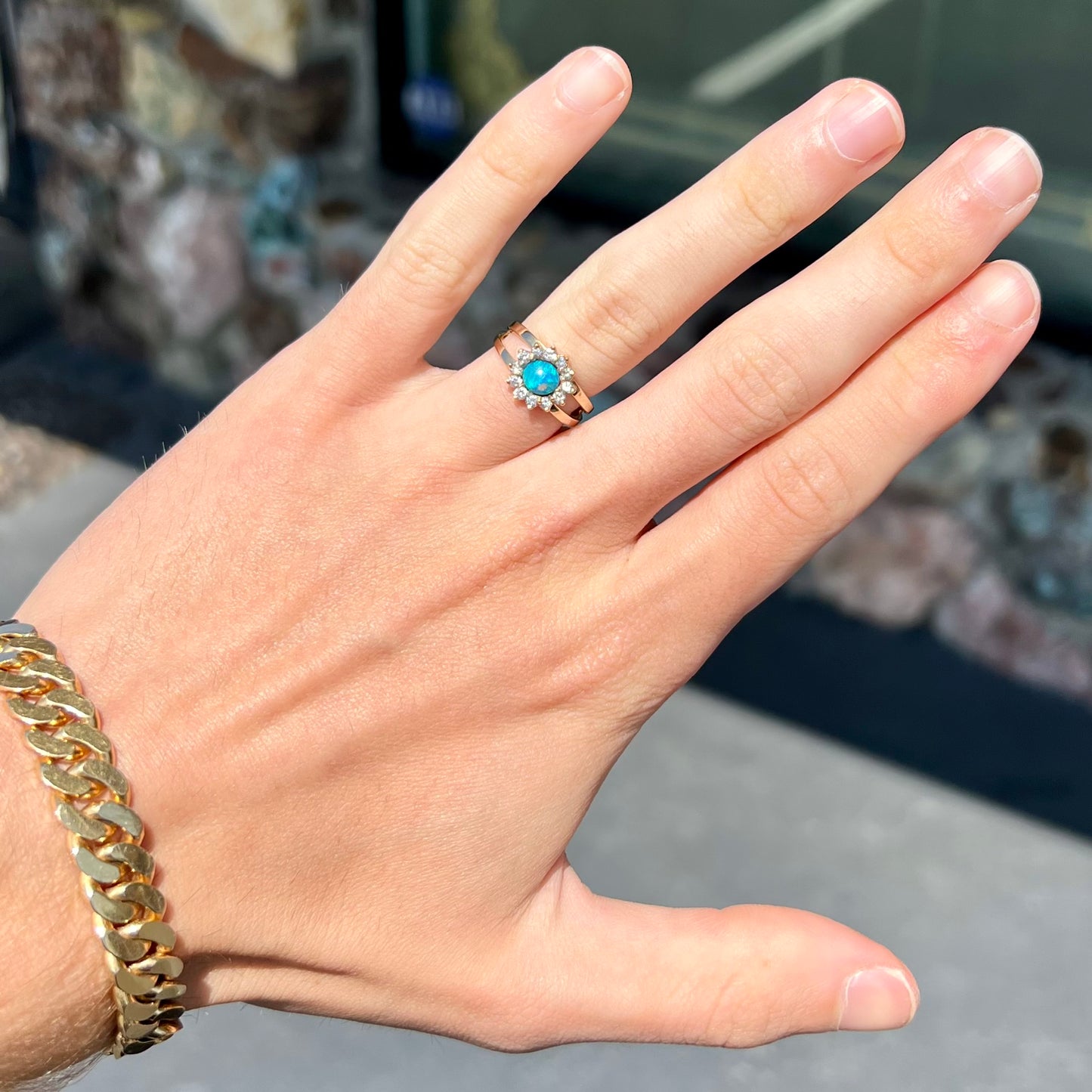 A ladies' round cut black opal and diamond halo ring. The ring is yellow gold and has a split shank.