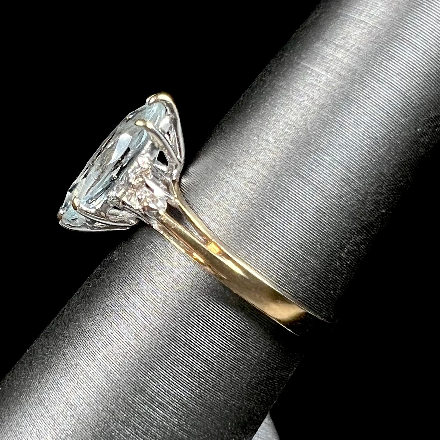 A ladies' ring set with a marquise cut aquamarine and round accent diamonds.