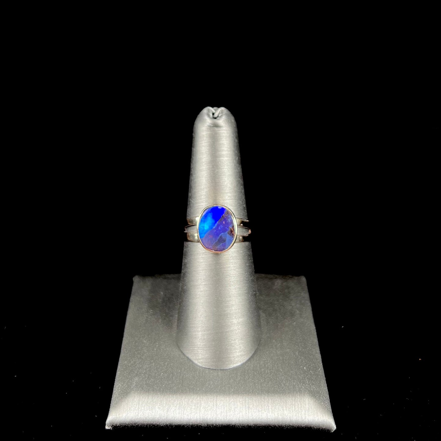 A ladies' split shank natural, Lightning Ridge, Australian black opal solitaire ring in yellow gold.