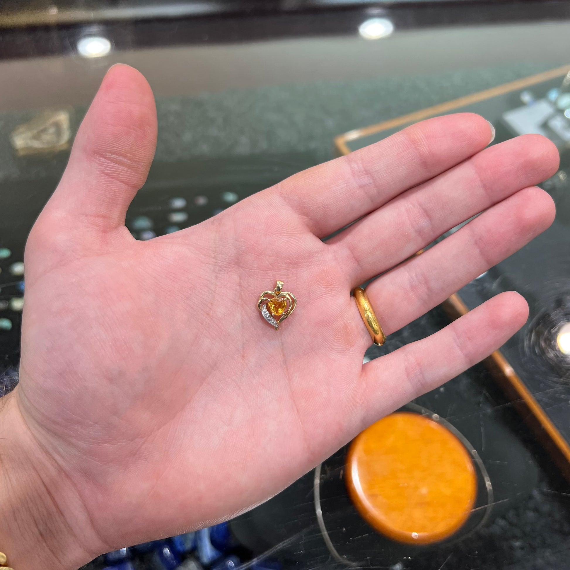 A ladies' yellow gold pendant set with a heart cut citrine stone and a diamond accent.
