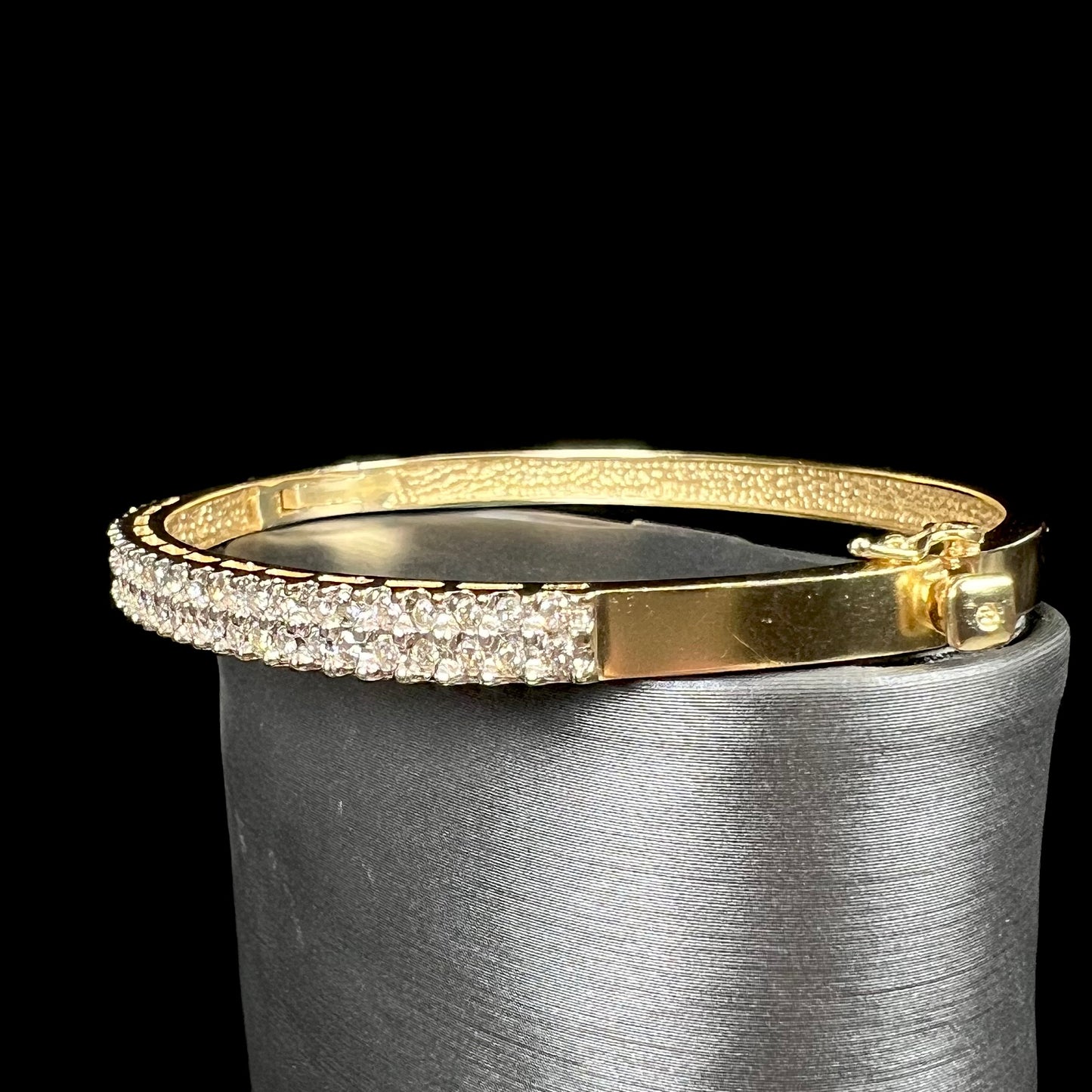 A ladies' hinged yellow gold bangle bracelet set with 50 Standard Round Brilliant Cut diamonds.