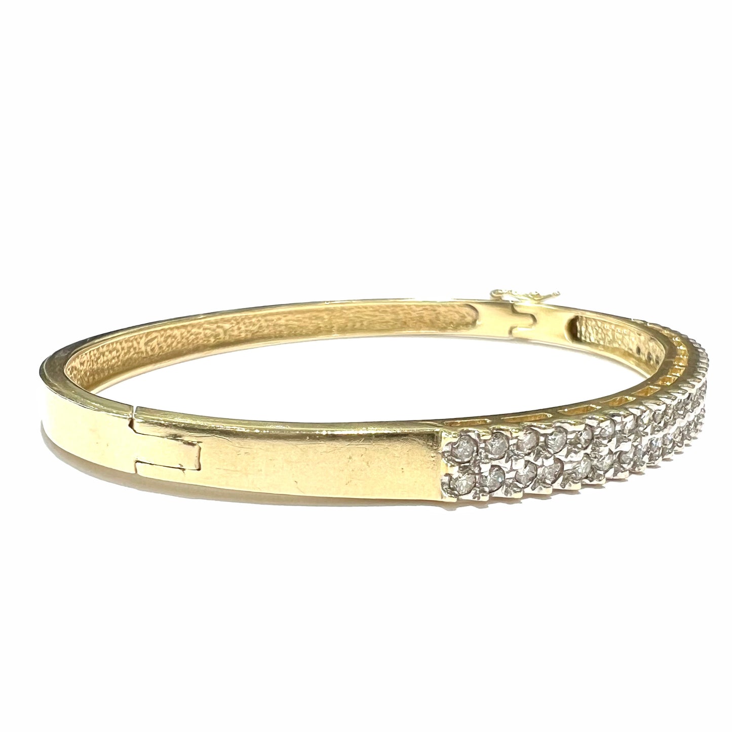 A ladies' hinged yellow gold bangle bracelet set with 50 Standard Round Brilliant Cut diamonds.