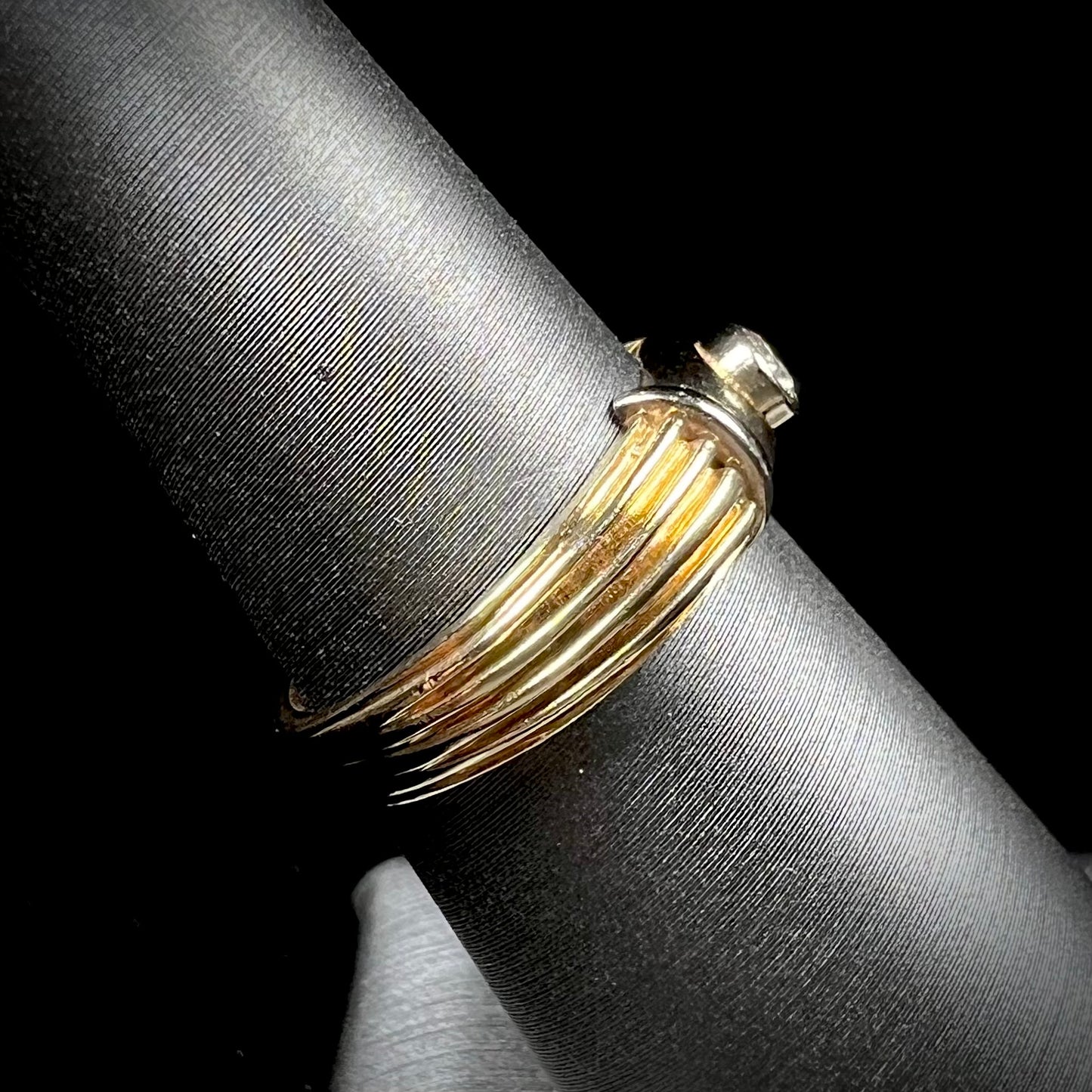 A unisex, vintage style two tone yellow and white gold wedding ring bezel set with a round diamond.