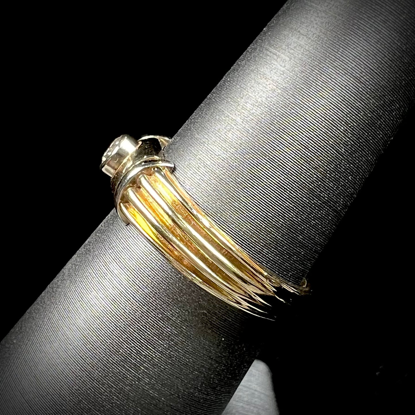 A unisex, vintage style two tone yellow and white gold wedding ring bezel set with a round diamond.