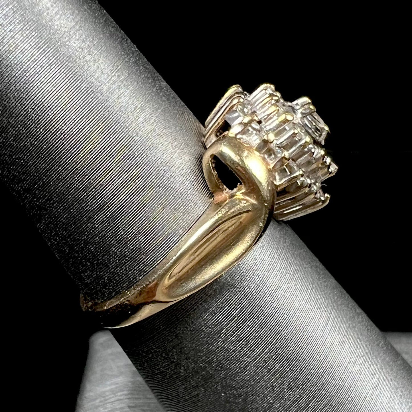 A ladies' heart shaped diamond cluster ring. The ring is set with pear shaped, baguette cut, and round diamonds.
