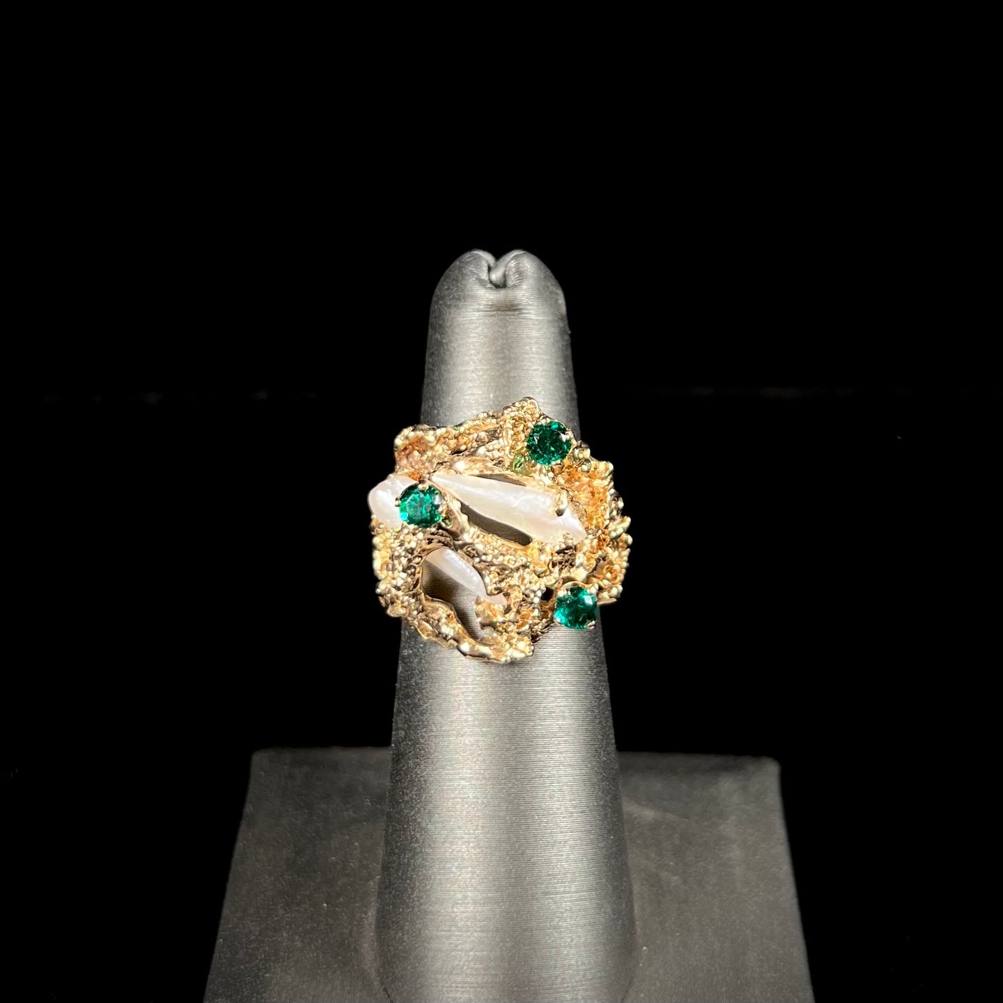 A vintage 1950's gold cluster ring set with freshwater pearls and green imitation emeralds.