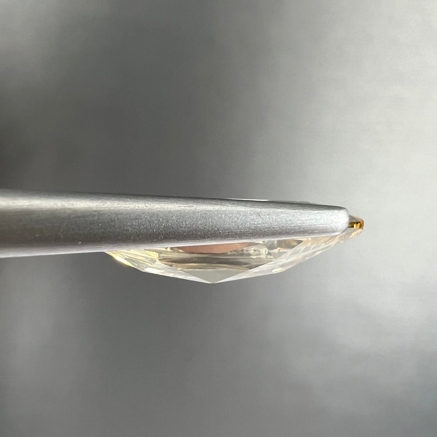 A loose, marquise cut golden beryl gemstone. The stone is a light yellow color.