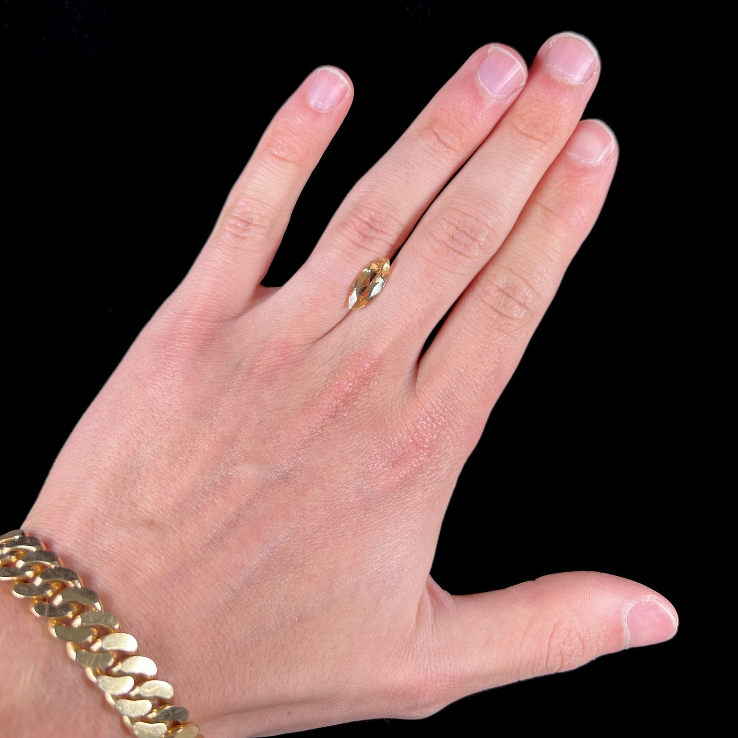 A loose, marquise cut golden beryl gemstone. The stone is a light yellow color.