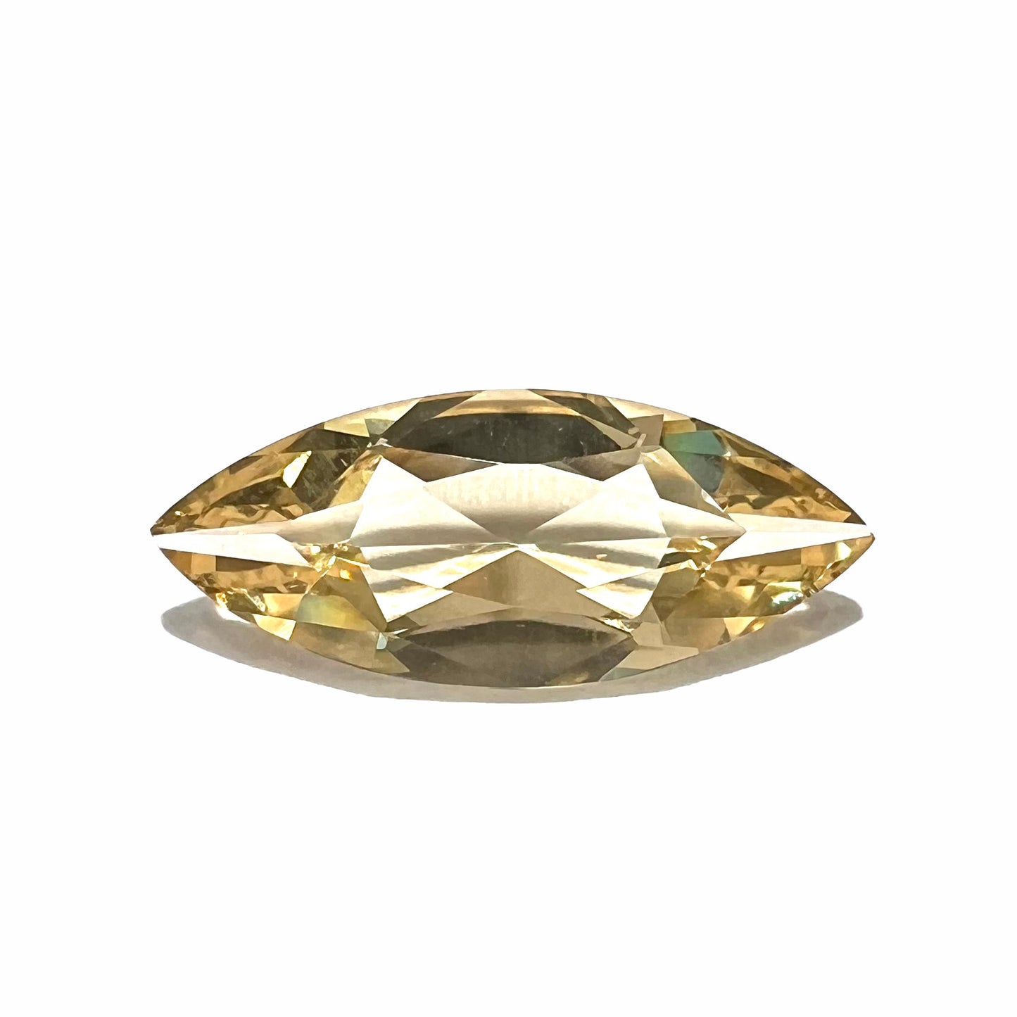 A loose, marquise cut golden beryl gemstone. The stone is a light yellow color.