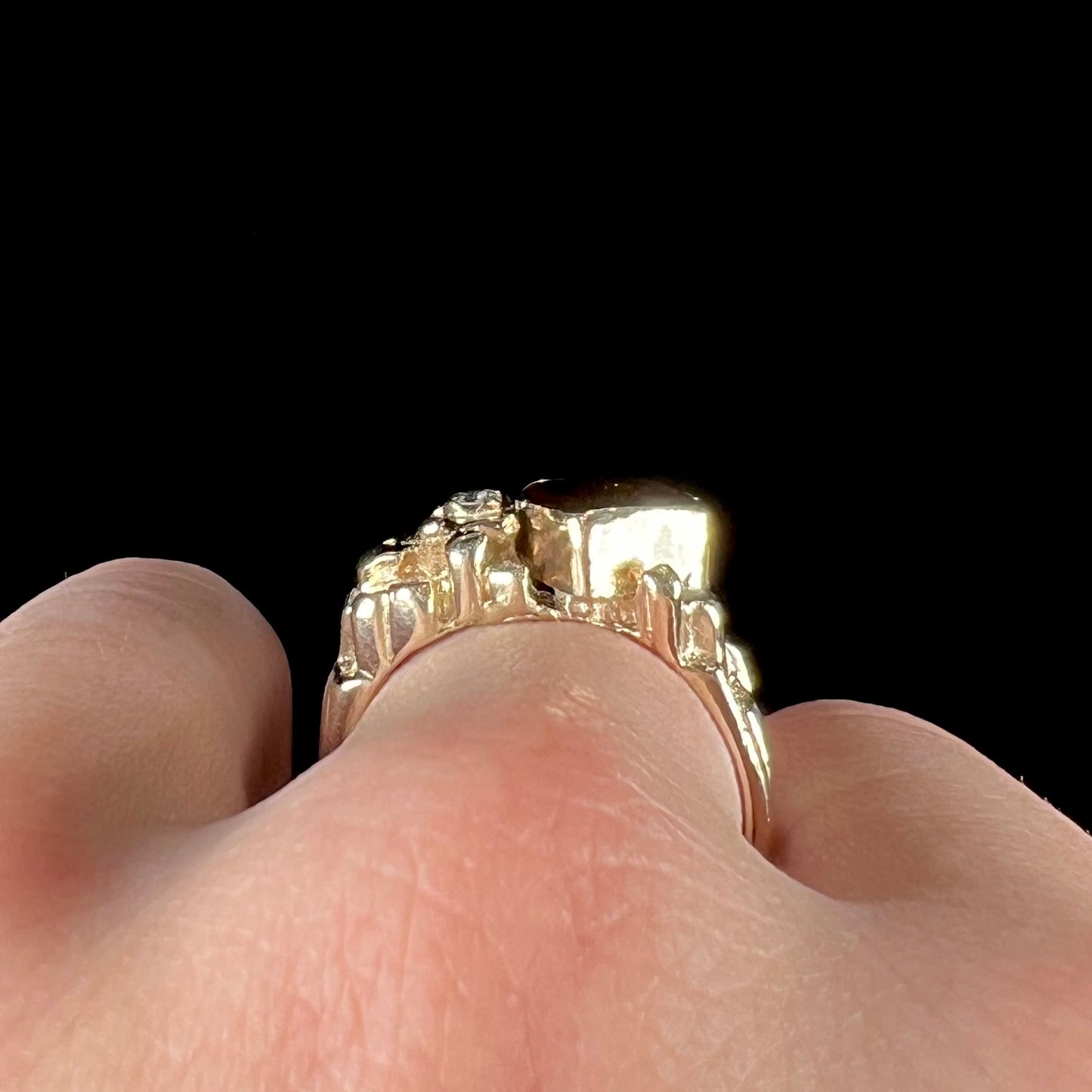 A men's yellow gold, nugget style ring set with a Mexican fire agate stone and a diamond accent.