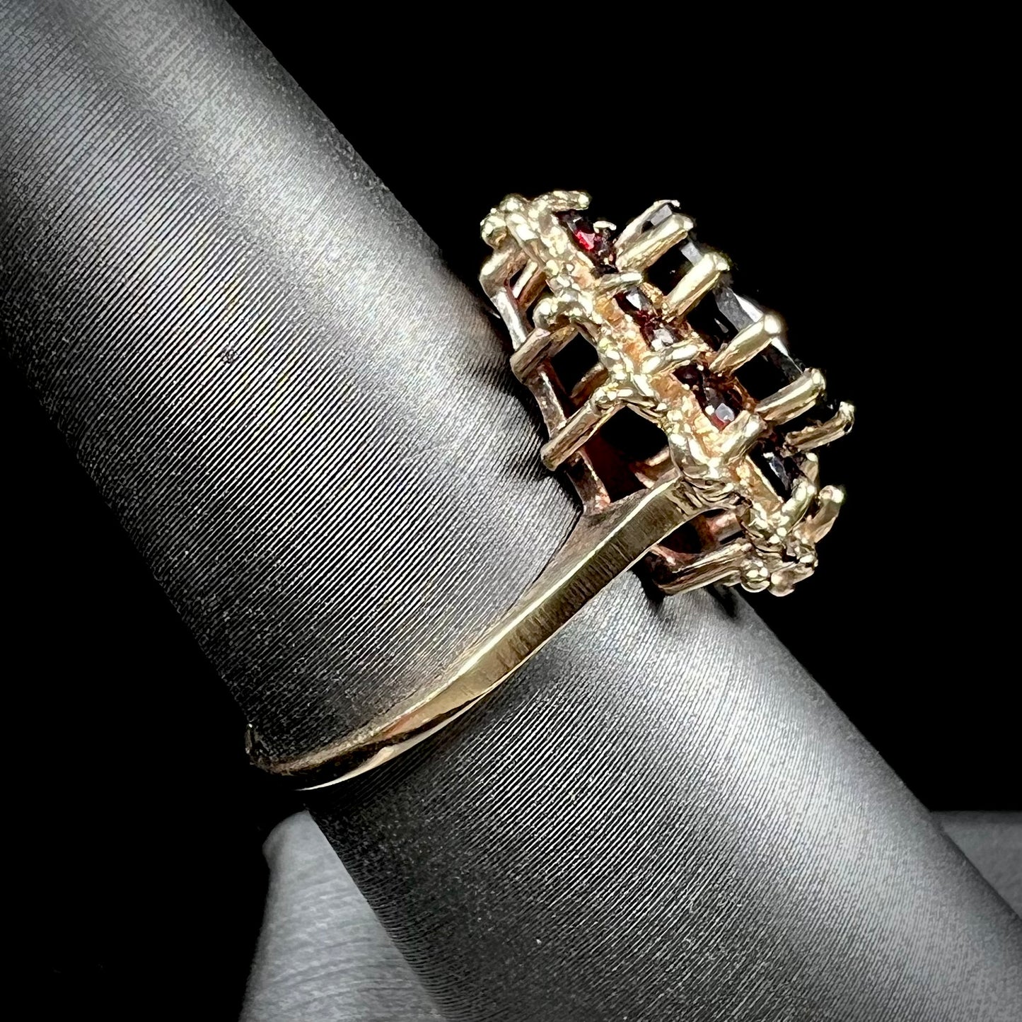 A vintage, 1940's style yellow gold ring set with a pear shaped almandine garnet. A halo of round garnets surround the center stone.