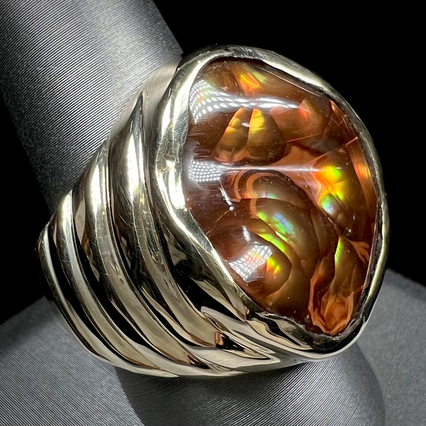 A men's heavy yellow gold ring set with a Mexican fire agate stone and three round brilliant cut diamond accents.