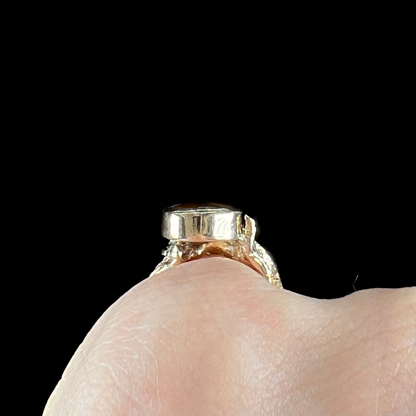 A ladies' yellow gold flower style ring set with an oval cabochon cut fire agate and diamond accents.