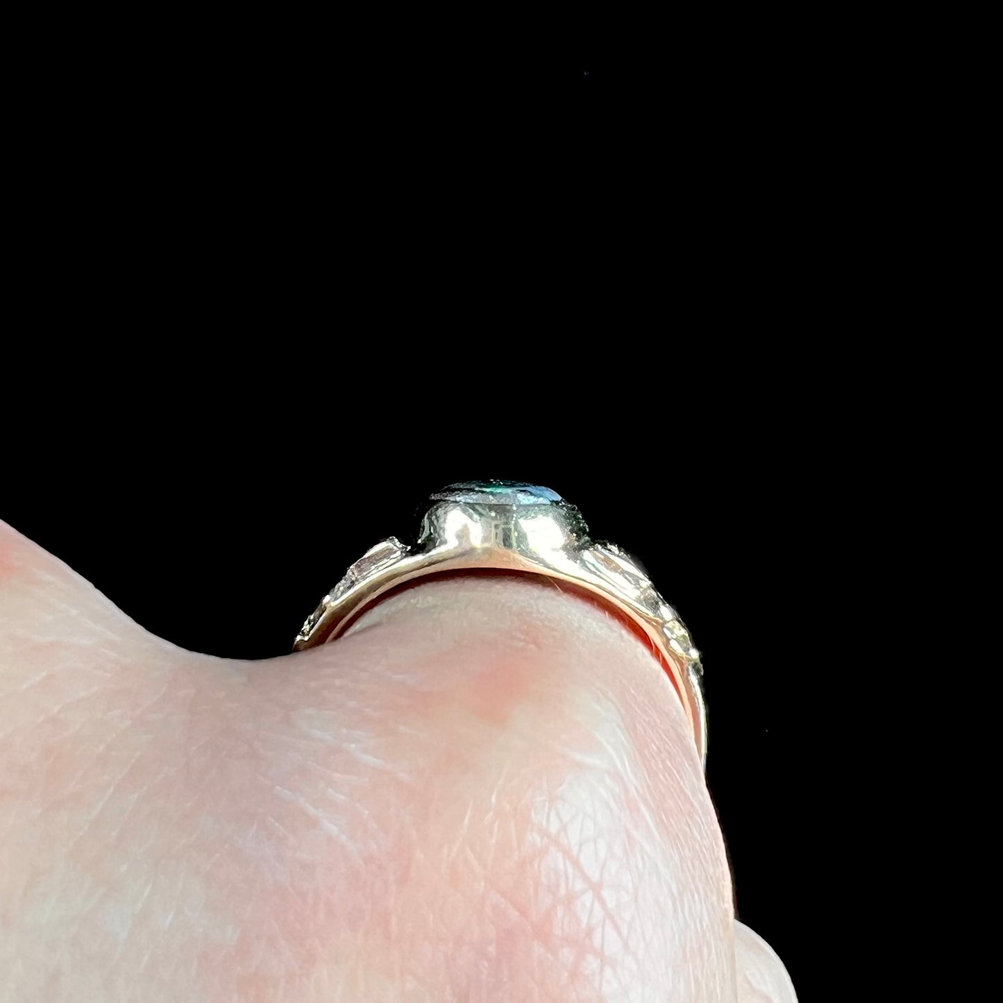 A unisex Celtic style natural boulder opal ring cast in yellow gold. The opal shines green and blue.
