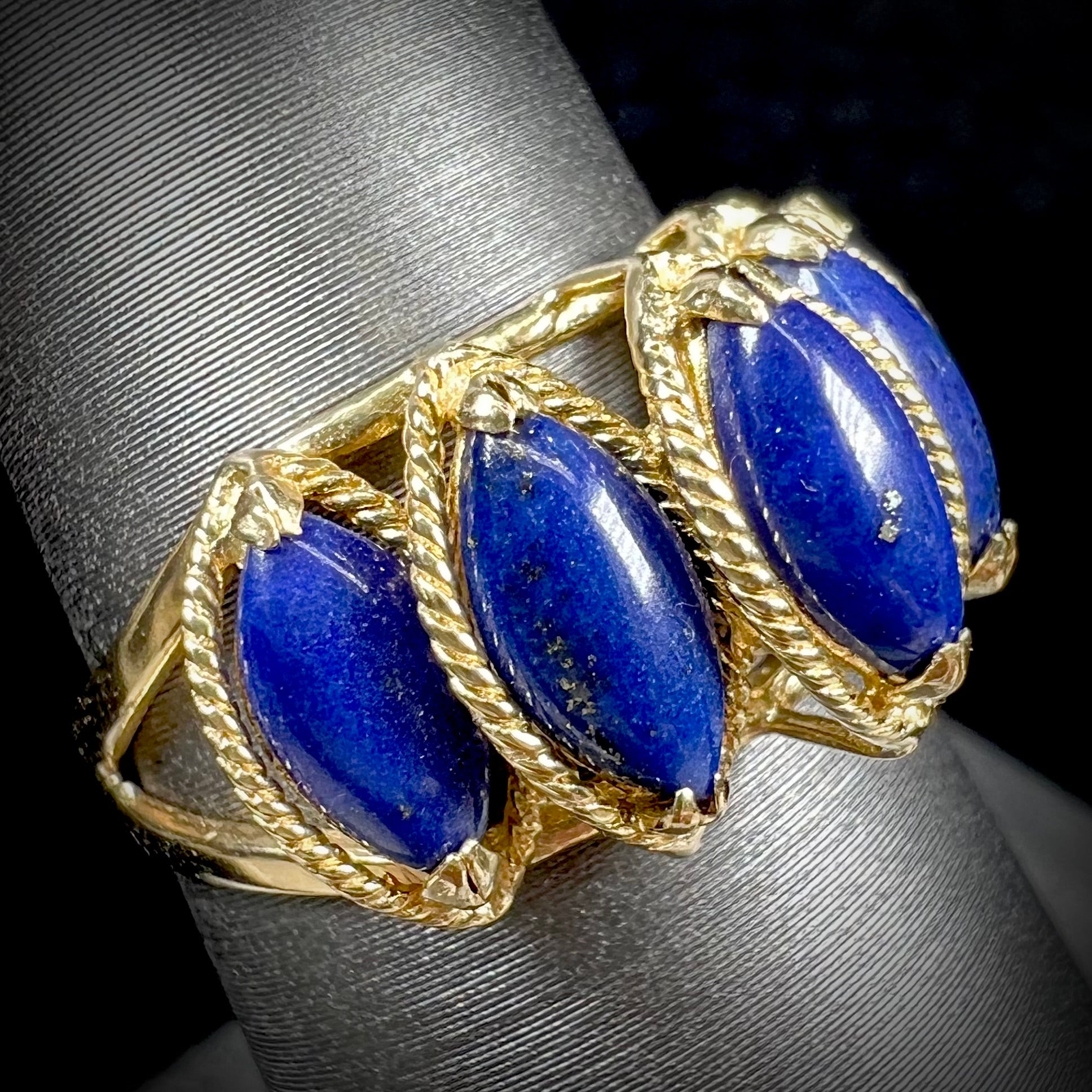 A ladies' five stone marquise cabochon cut lapis lazuli ring in yellow gold.