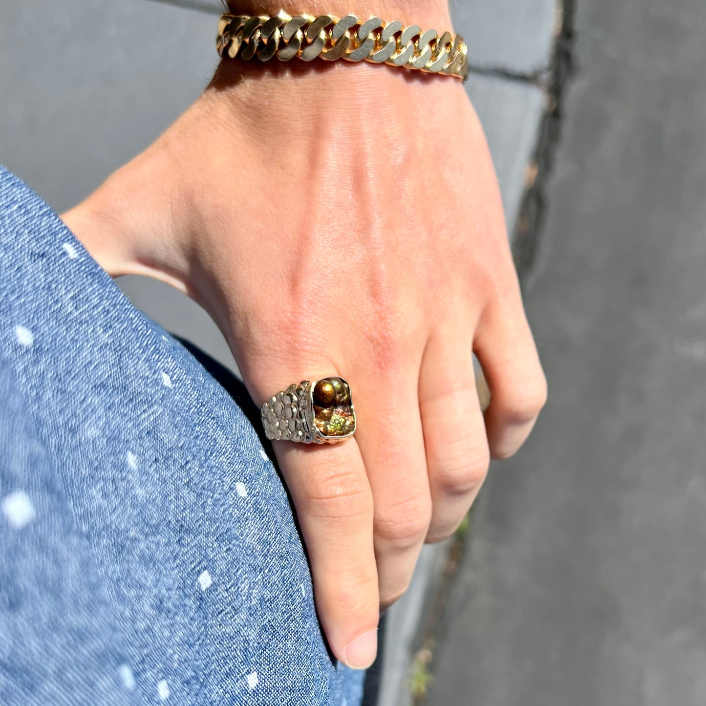 A men's yellow gold, nugget style ring set with a bubbly, California fire agate stone.