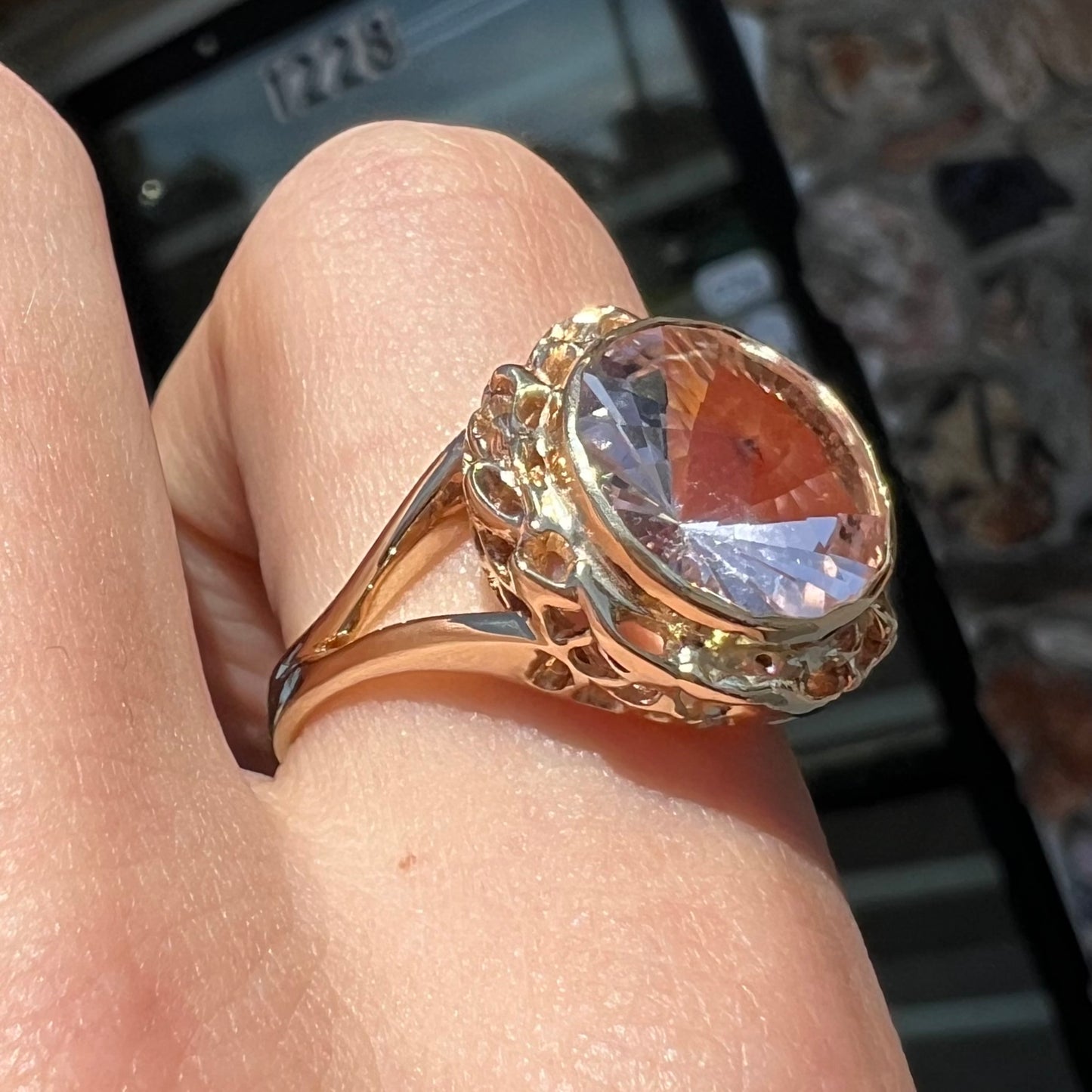 A ladies' yellow gold solitaire ring bezel set with a modified bud cut morganite gemstone.